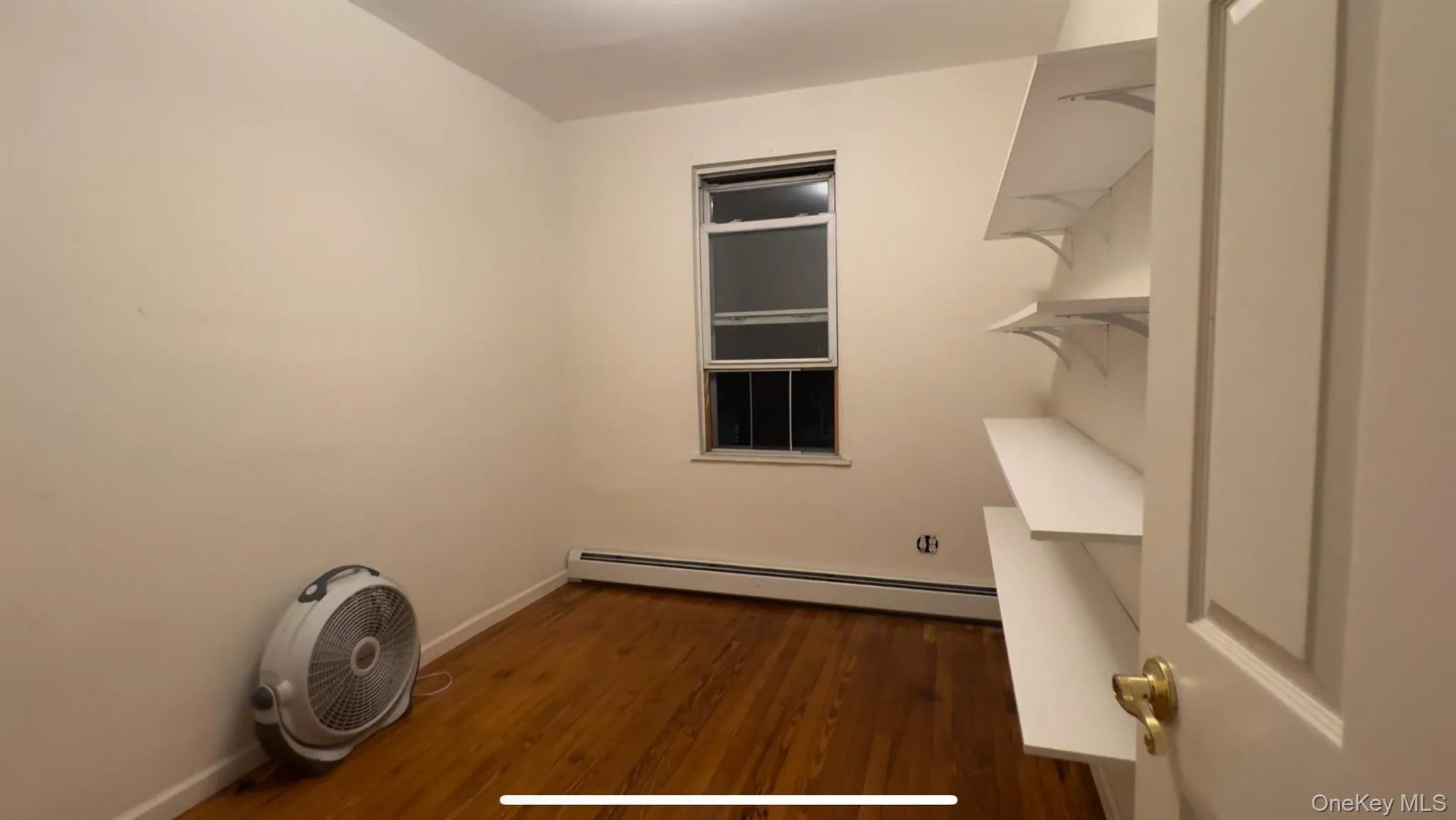 Washroom featuring dark wood-style flooring and a baseboard radiator Washroom featuring dark wood-style flooring and a baseboard radiator