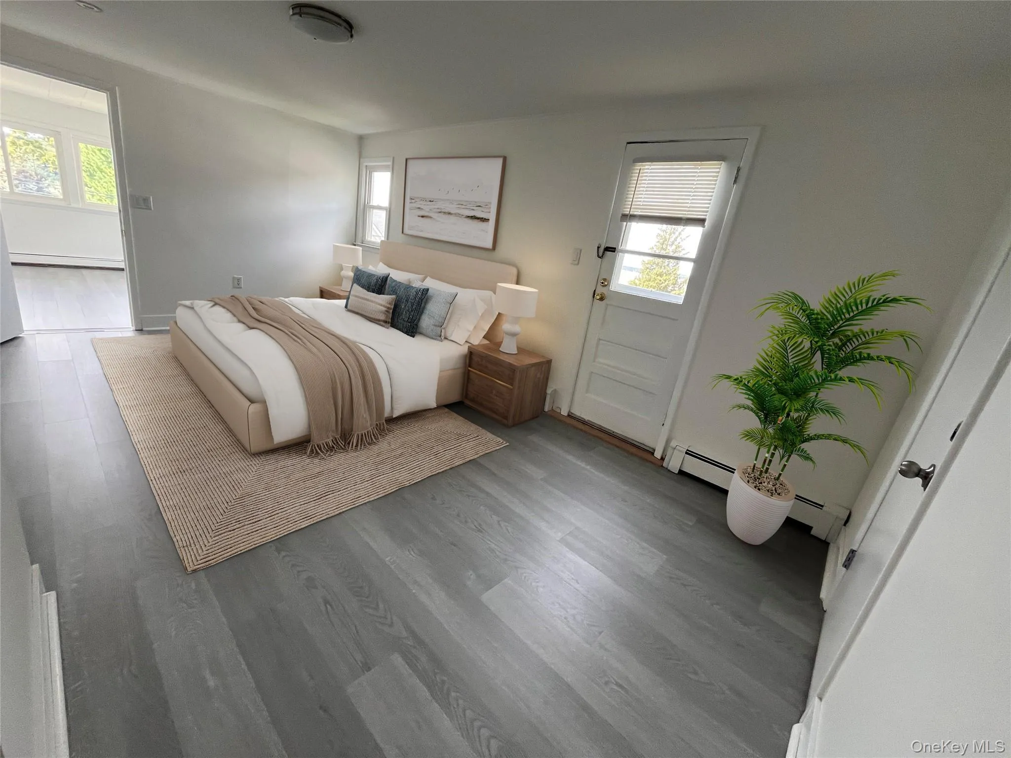 Bedroom with wood finished floors, multiple windows, and a baseboard heating unit Bedroom with wood finished floors, multiple windows, and a baseboard heating unit