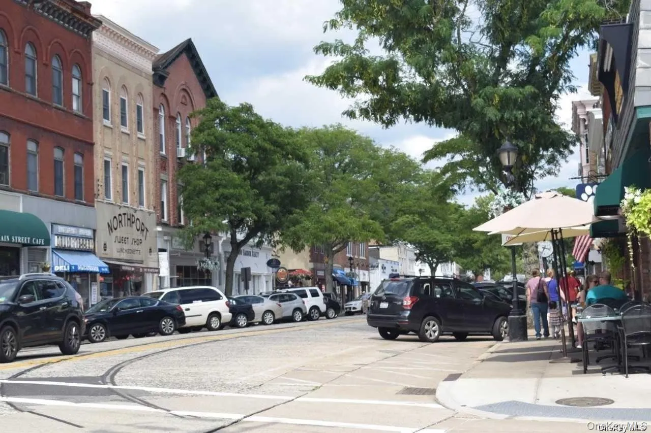 View of asphalt street featuring street lighting, sidewalks, and curbs View of asphalt street featuring street lighting, sidewalks, and curbs