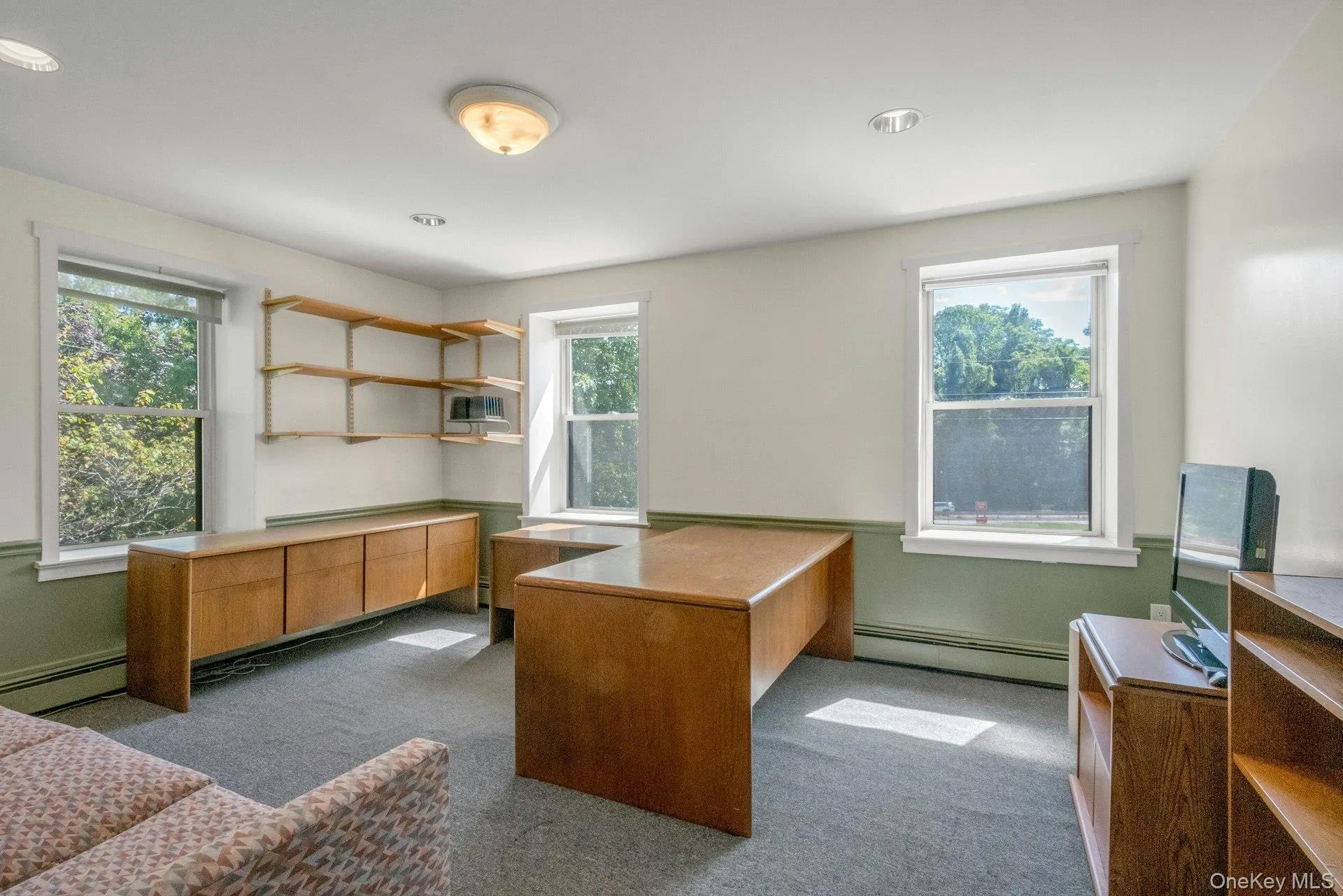 Office featuring dark colored carpet, baseboard heating, and a baseboard heating unit Office featuring dark colored carpet, baseboard heating, and a baseboard heating unit
