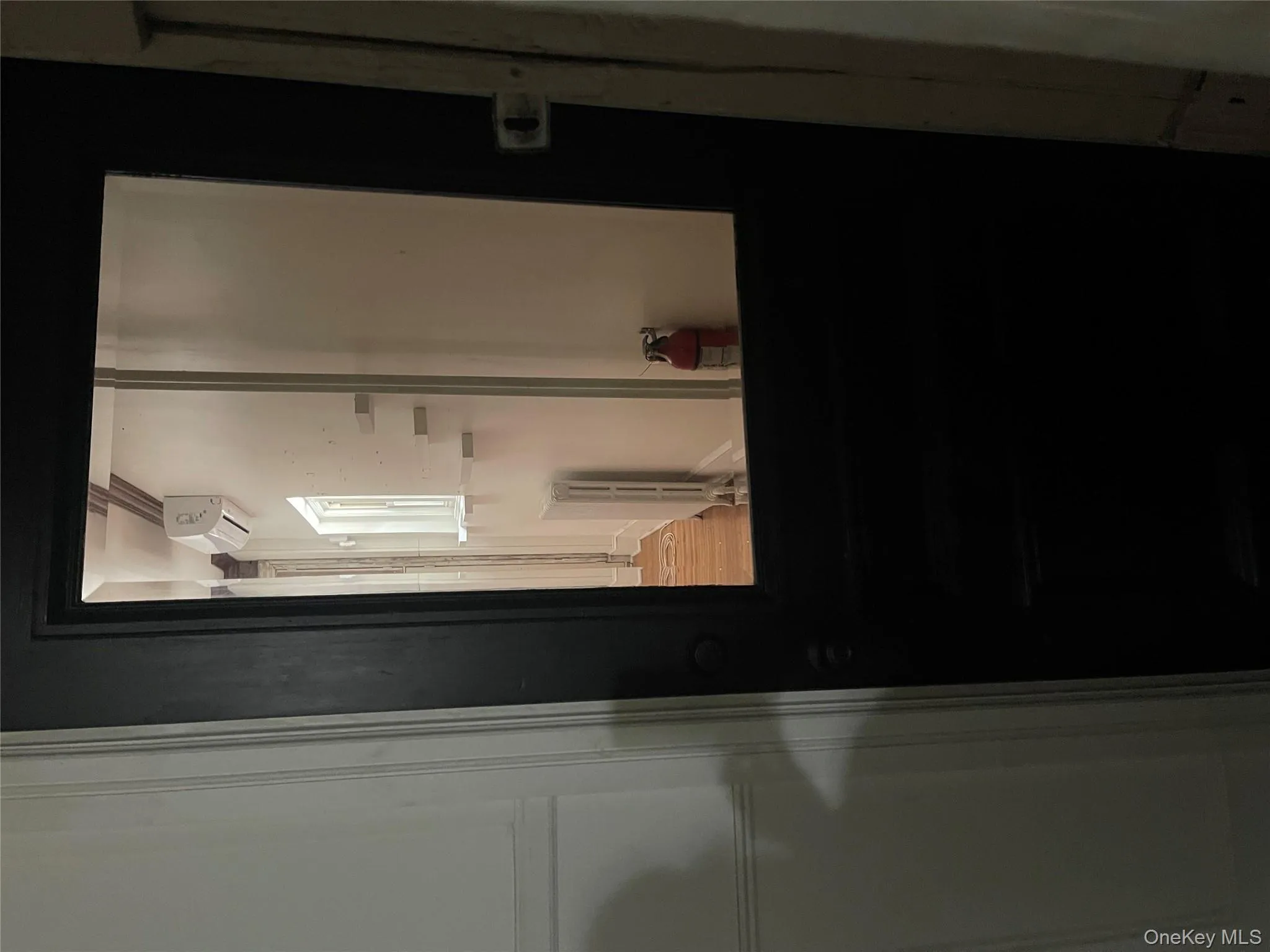 Corridor with wood finished floors, radiator, and a wall mounted air conditioner Corridor with wood finished floors, radiator, and a wall mounted air conditioner