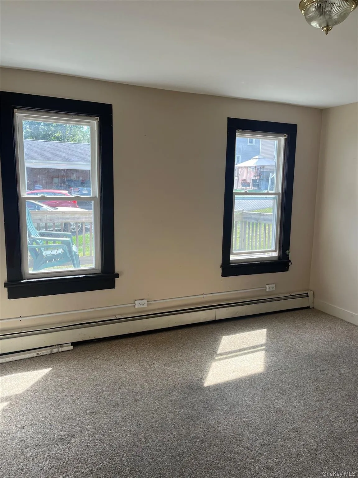 Carpeted spare room featuring a baseboard heating unit and baseboards Carpeted spare room featuring a baseboard heating unit and baseboards