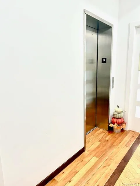 Hallway with light wood-style floors and elevator Hallway with light wood-style floors and elevator