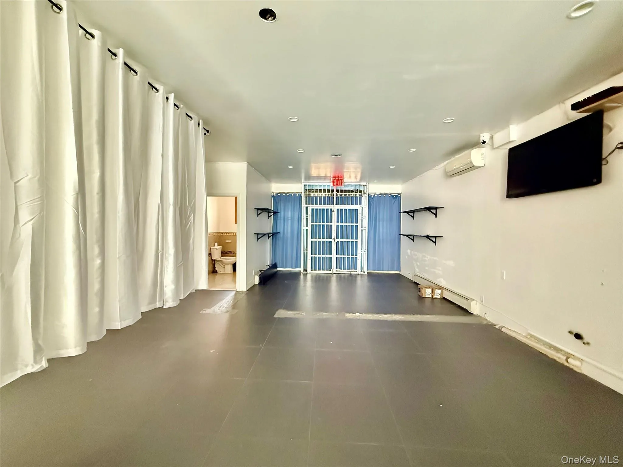 Workout area featuring tile patterned flooring, recessed lighting, and an AC wall unit Workout area featuring tile patterned flooring, recessed lighting, and an AC wall unit
