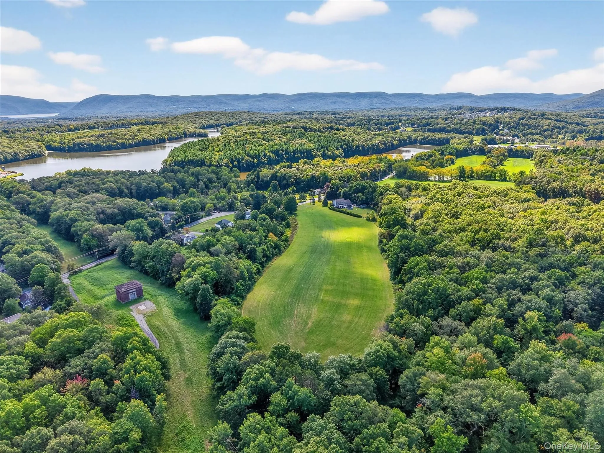 Drone / aerial view of a water and mountain view and a heavily wooded area Drone / aerial view of a water and mountain view and a heavily wooded area