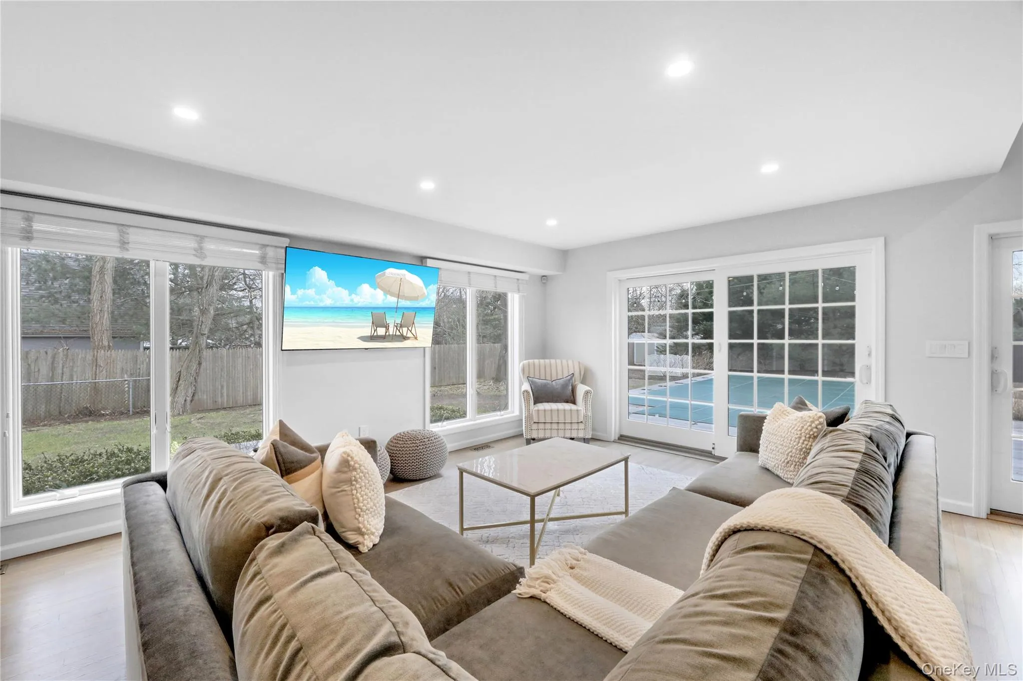 Living room with light wood finished floors and recessed lighting Living room with light wood finished floors and recessed lighting