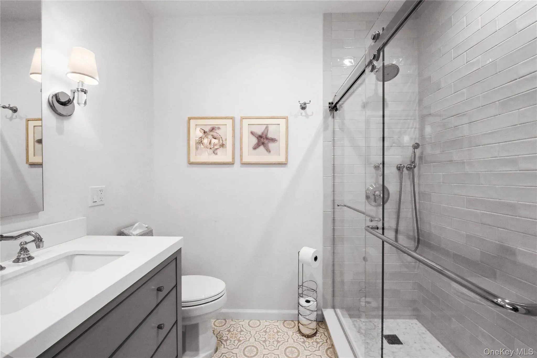 Bathroom featuring vanity, a shower stall, and light tile patterned flooring Bathroom featuring vanity, a shower stall, and light tile patterned flooring