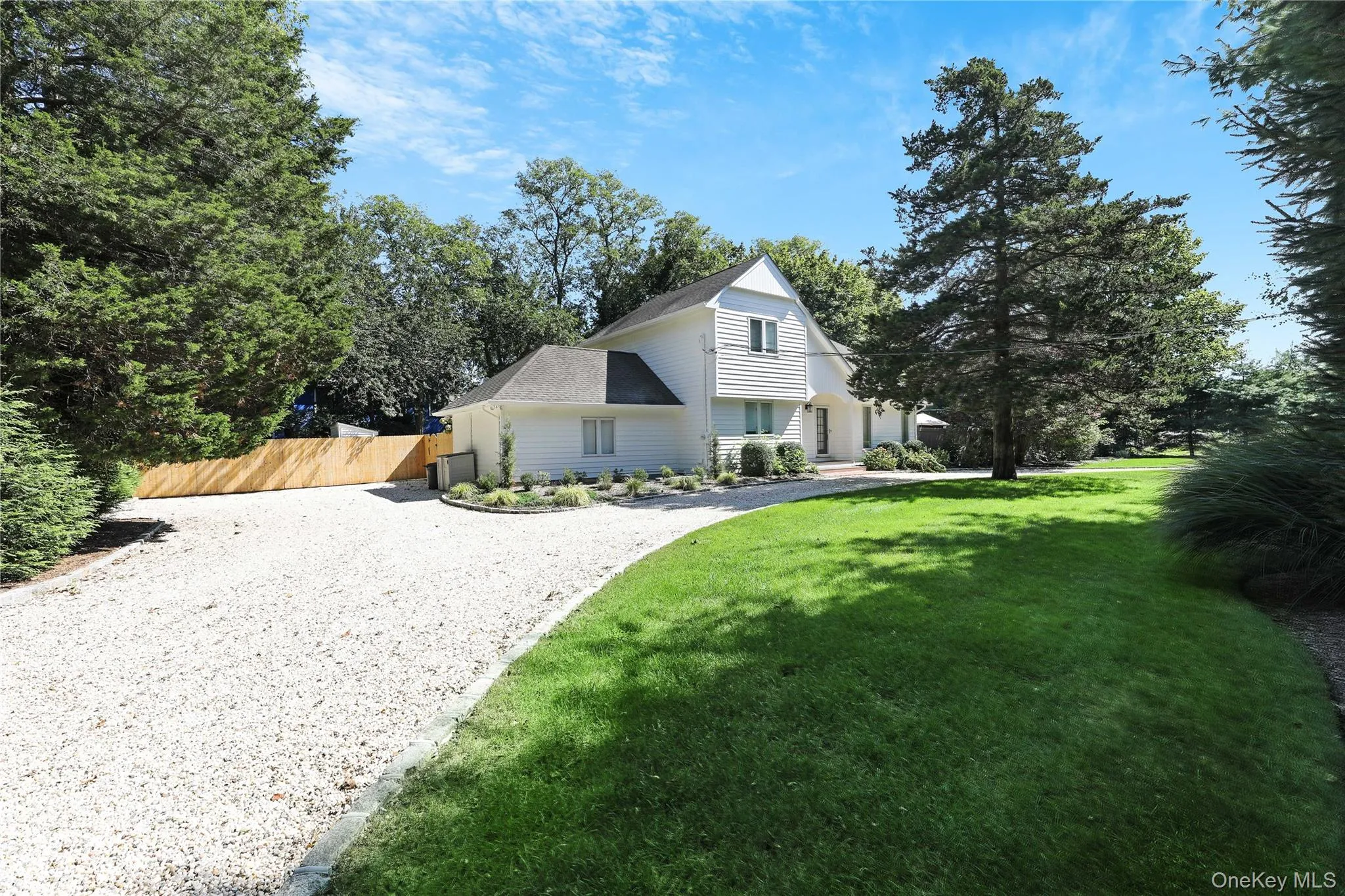View of front facade featuring driveway and a shingled roof View of front facade featuring driveway and a shingled roof