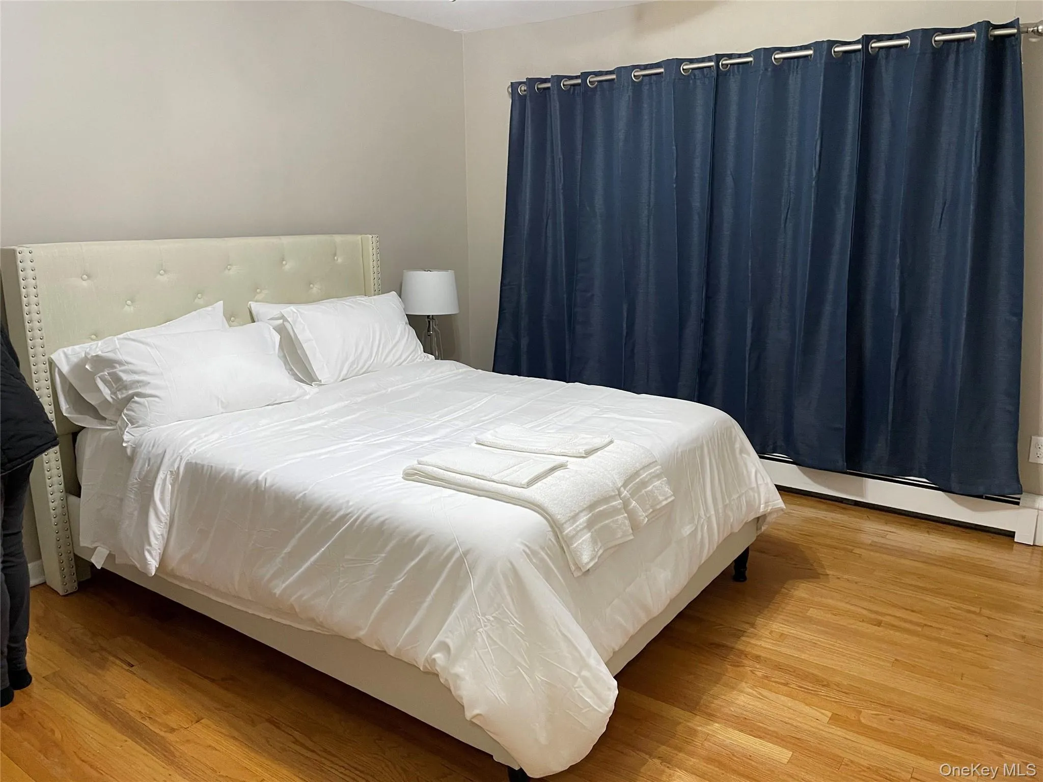 Bedroom with light wood finished floors and a baseboard heating unit Bedroom with light wood finished floors and a baseboard heating unit