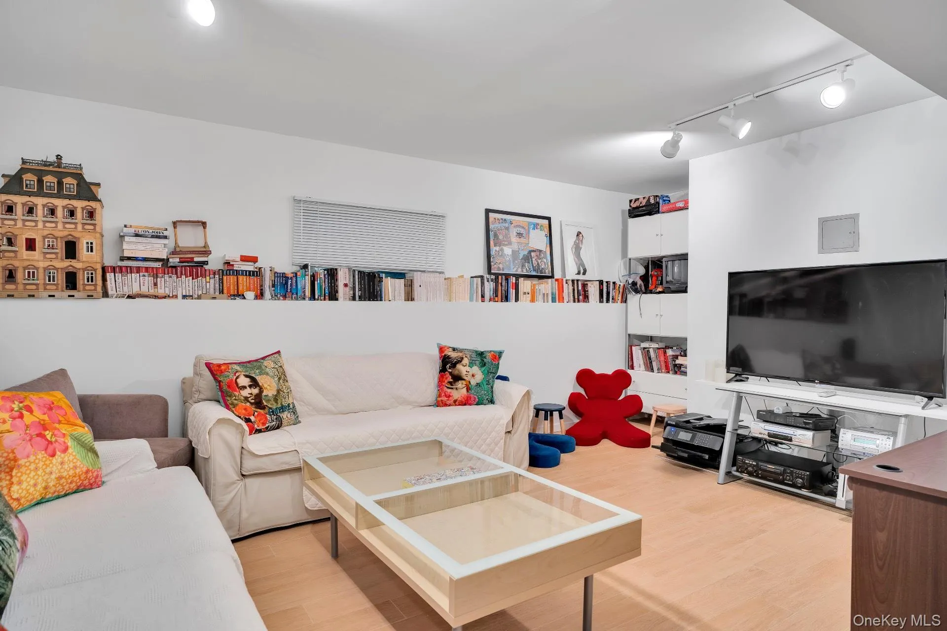Living area featuring wood finished floors and rail lighting Living area featuring wood finished floors and rail lighting