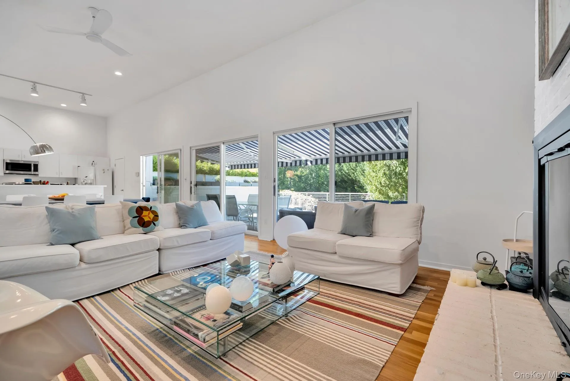 Living area with a high ceiling, light wood-style floors, ceiling fan, and recessed lighting Living area with a high ceiling, light wood-style floors, ceiling fan, and recessed lighting
