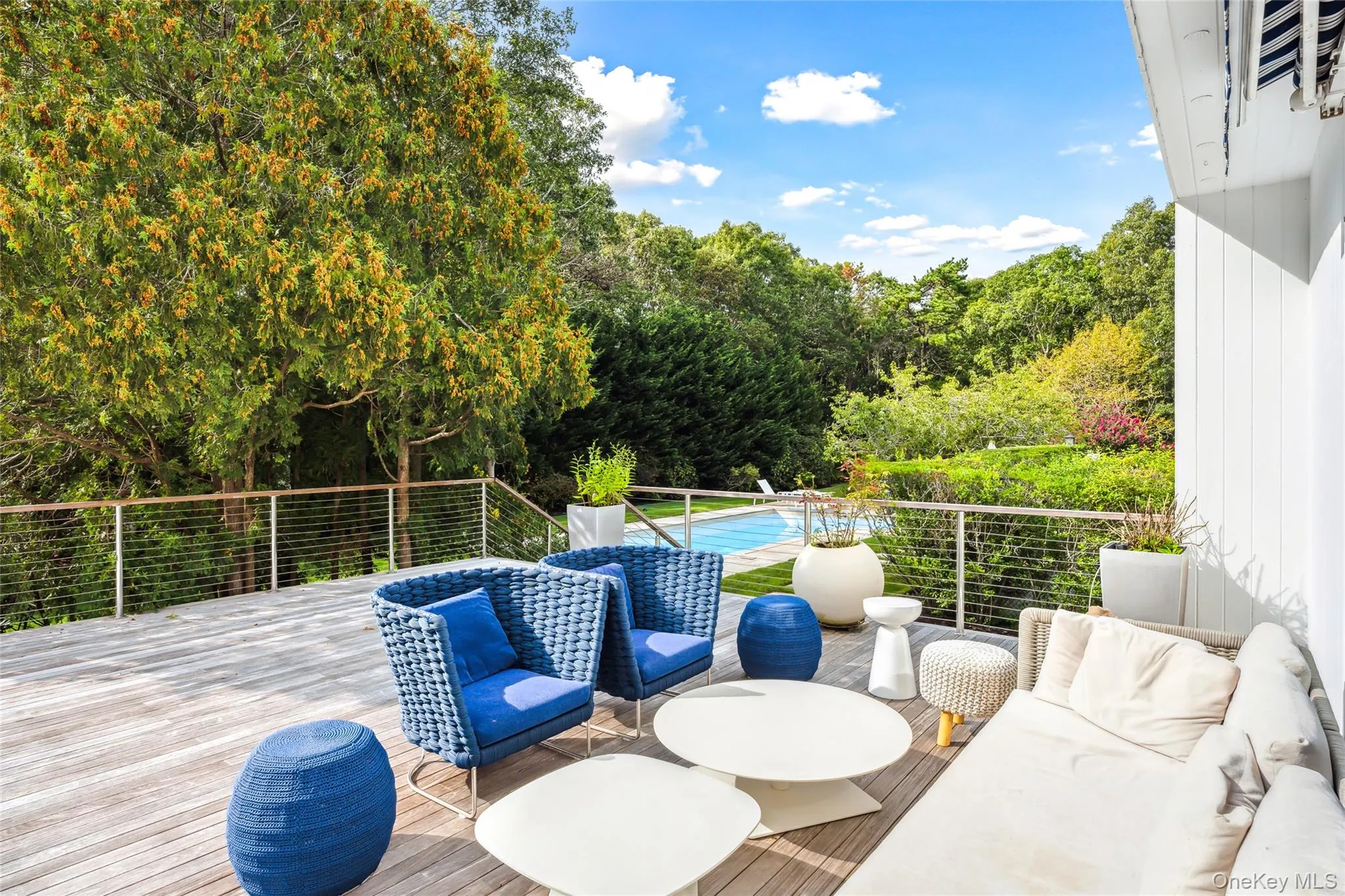 View of patio with an outdoor living space, view of scattered trees, and a wooden deck View of patio with an outdoor living space, view of scattered trees, and a wooden deck