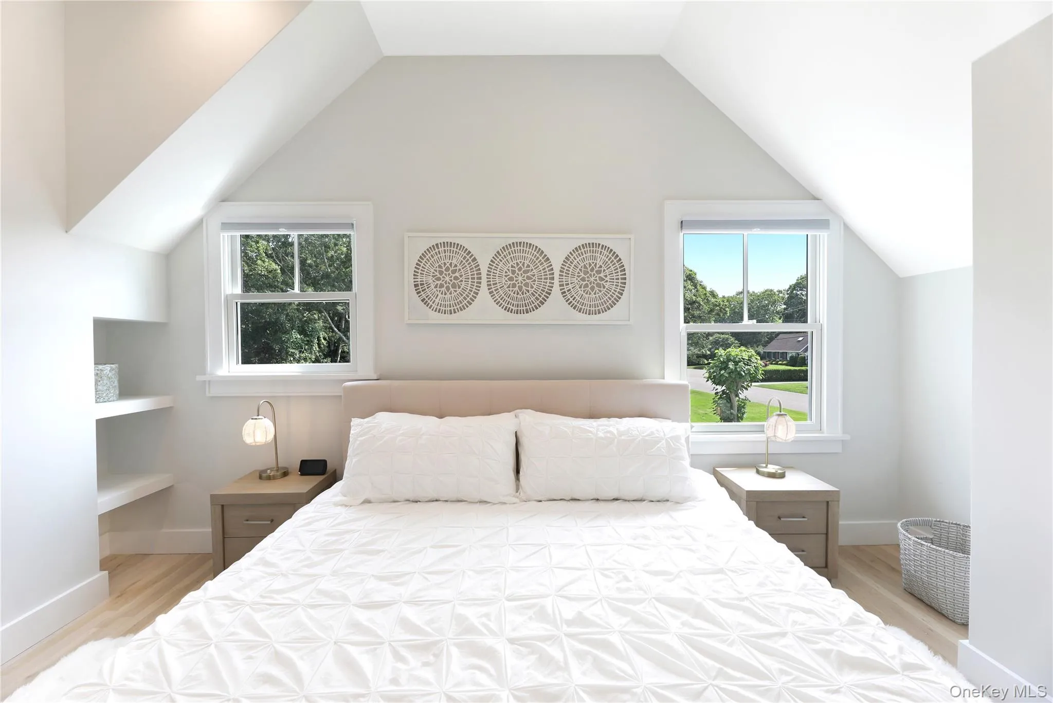 Bedroom featuring vaulted ceiling and light wood-style flooring Bedroom featuring vaulted ceiling and light wood-style flooring