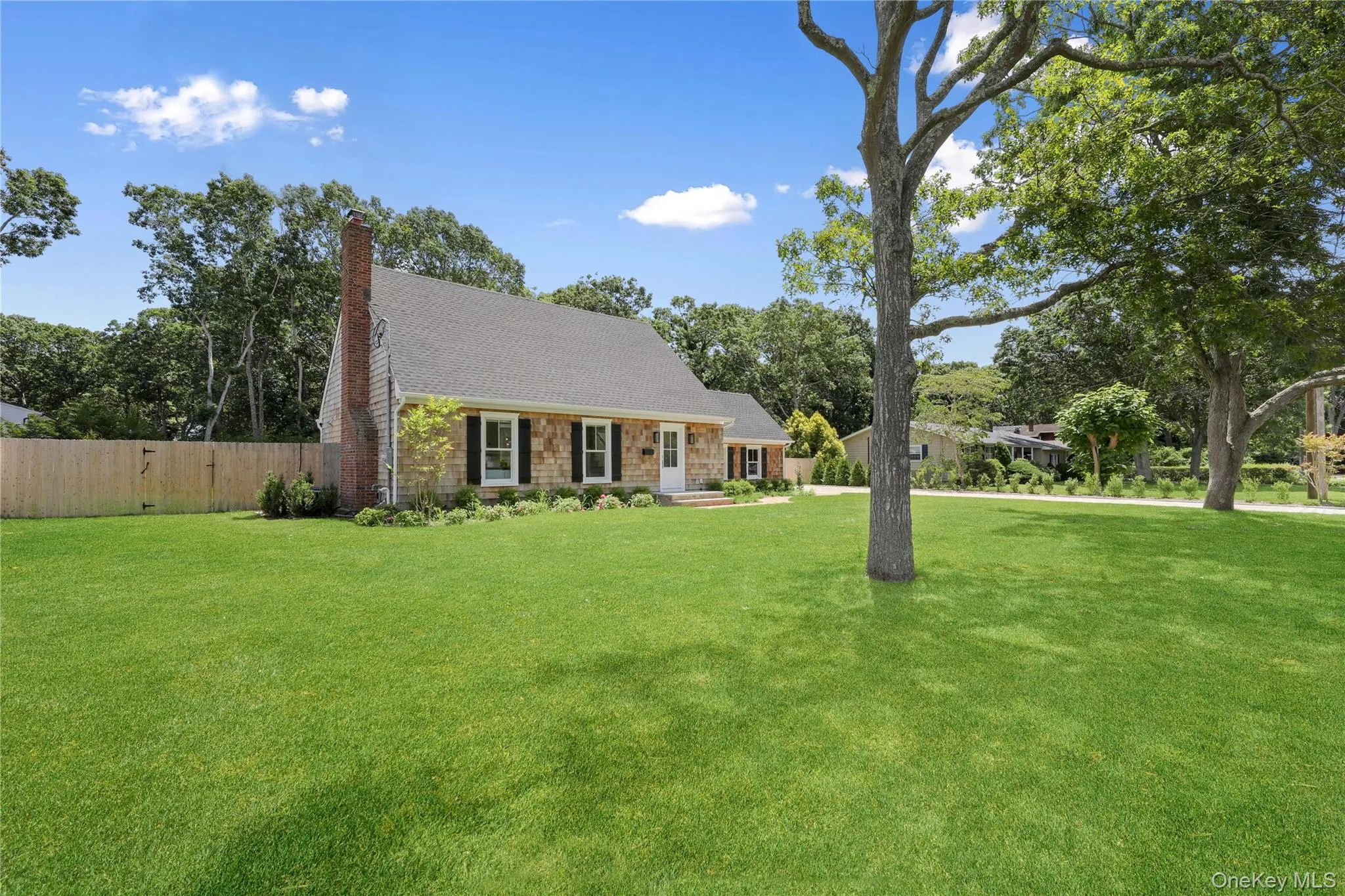 Cape cod-style house with a chimney, roof with shingles, and stone siding Cape cod-style house with a chimney, roof with shingles, and stone siding