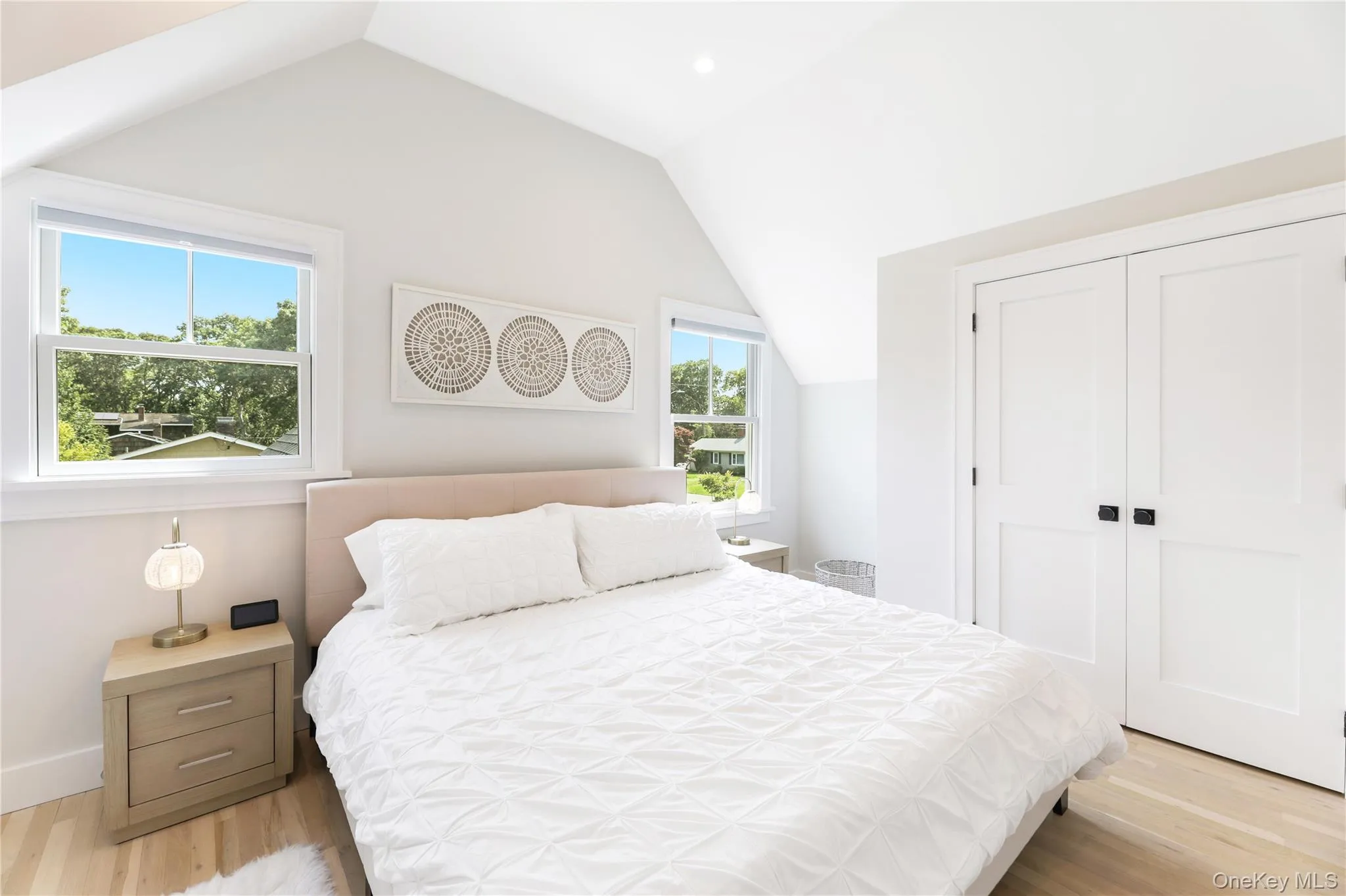 Bedroom with light wood-type flooring, lofted ceiling, a closet, and recessed lighting Bedroom with light wood-type flooring, lofted ceiling, a closet, and recessed lighting