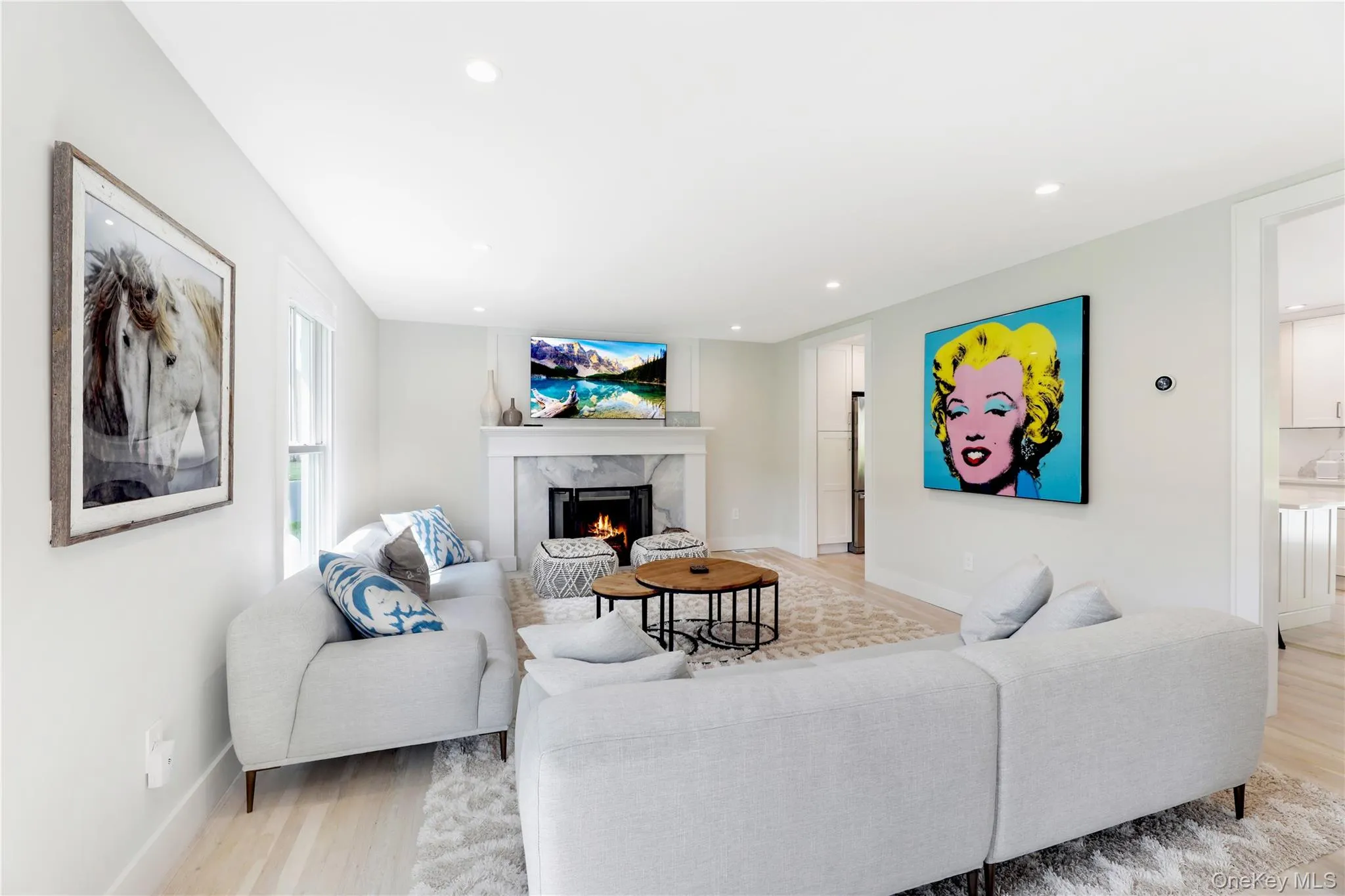 Living area featuring a high end fireplace, light wood finished floors, and recessed lighting Living area featuring a high end fireplace, light wood finished floors, and recessed lighting