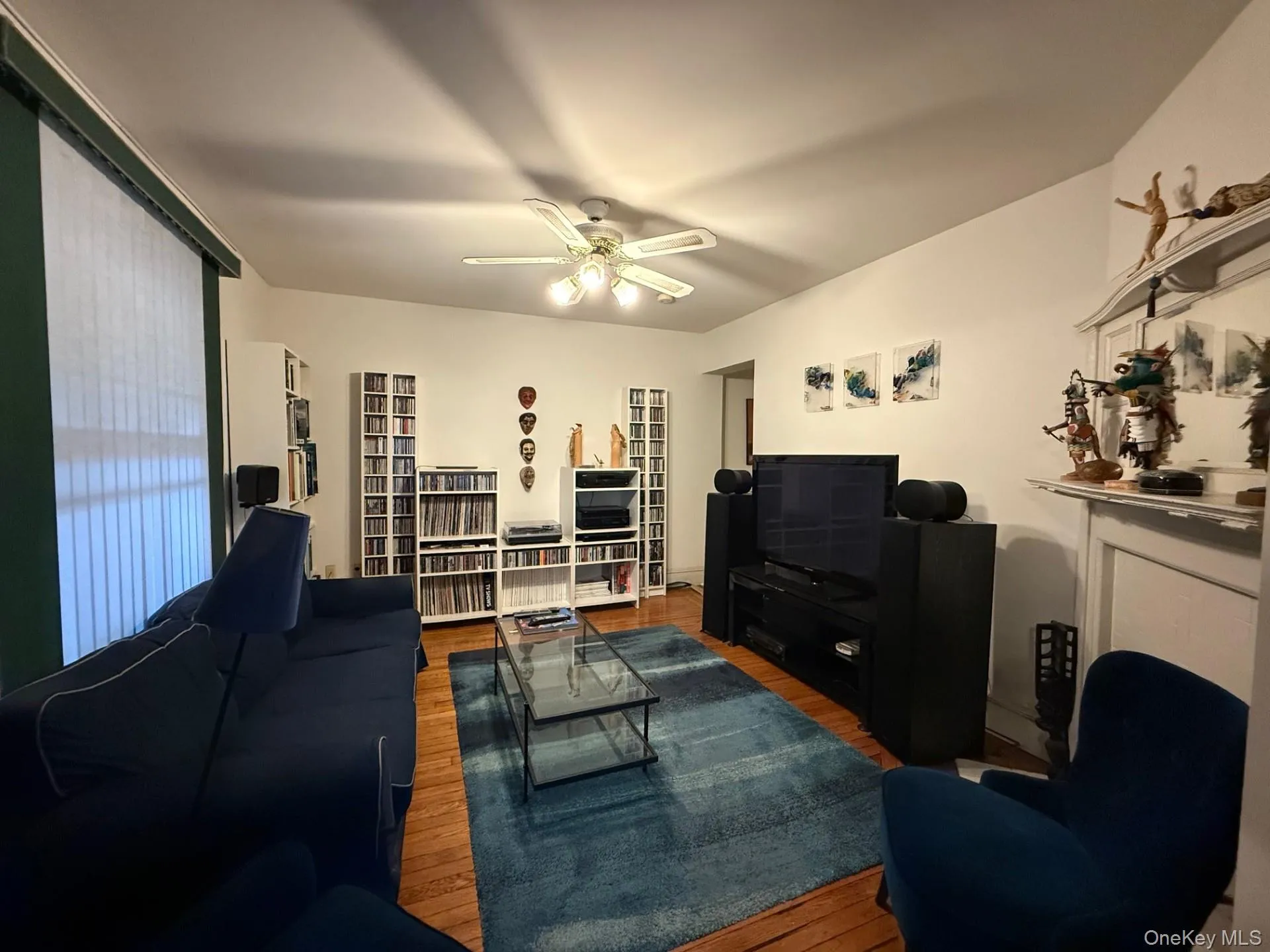 Living area featuring wood finished floors and a ceiling fan Living area featuring wood finished floors and a ceiling fan