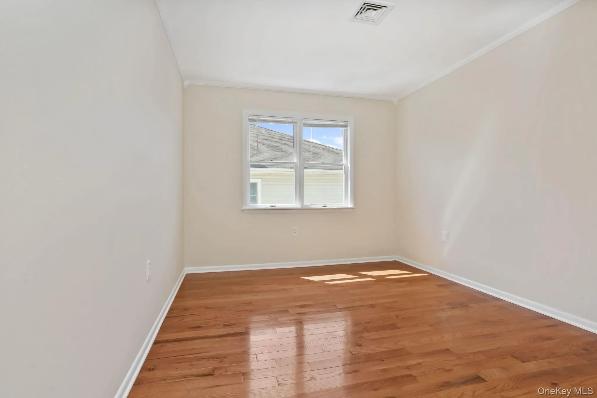 Bedroom 2 featuring light wood-style flooring and molding Bedroom 2 featuring light wood-style flooring and molding