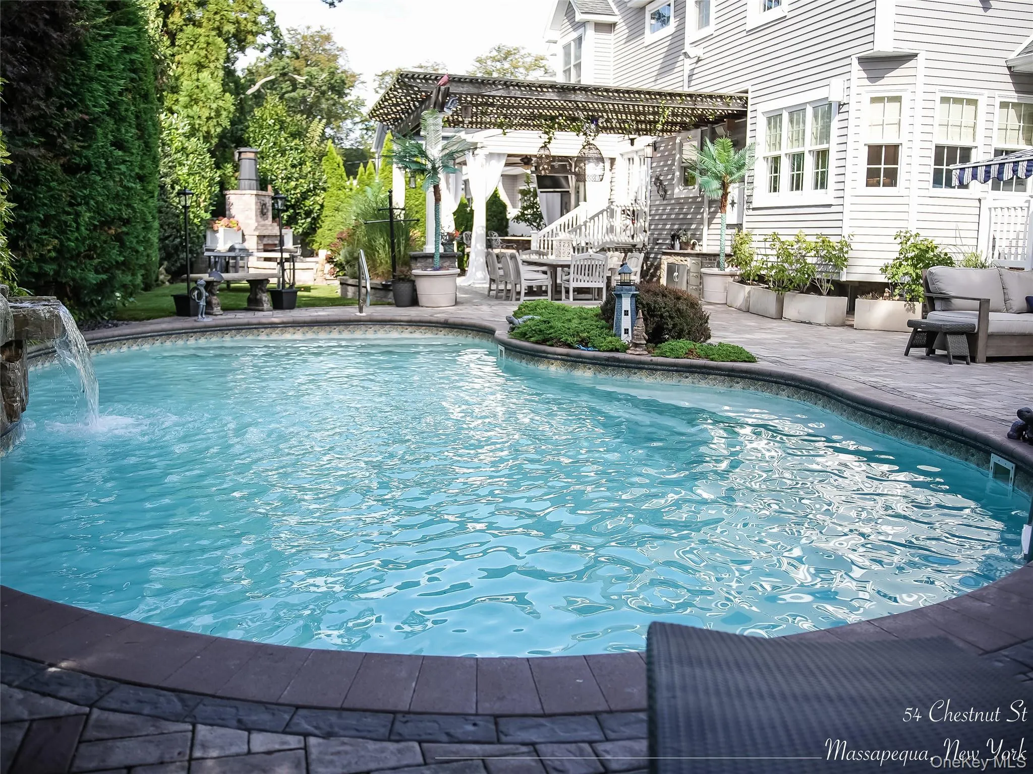 Swimming pool with a patio area and a pergola Swimming pool with a patio area and a pergola