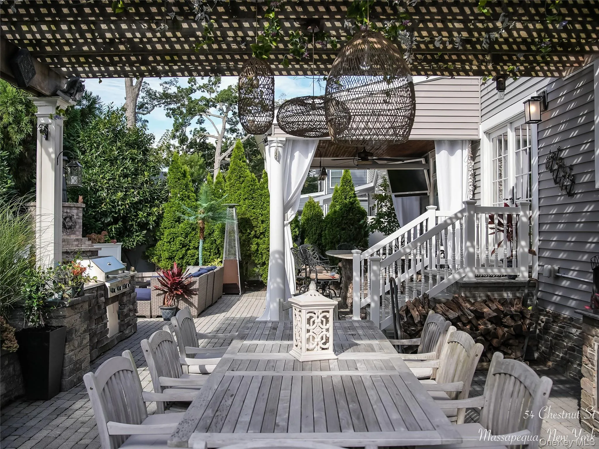 View of patio with outdoor dining area, exterior kitchen, a deck, a ceiling fan, and view of scattered trees View of patio with outdoor dining area, exterior kitchen, a deck, a ceiling fan, and view of scattered trees