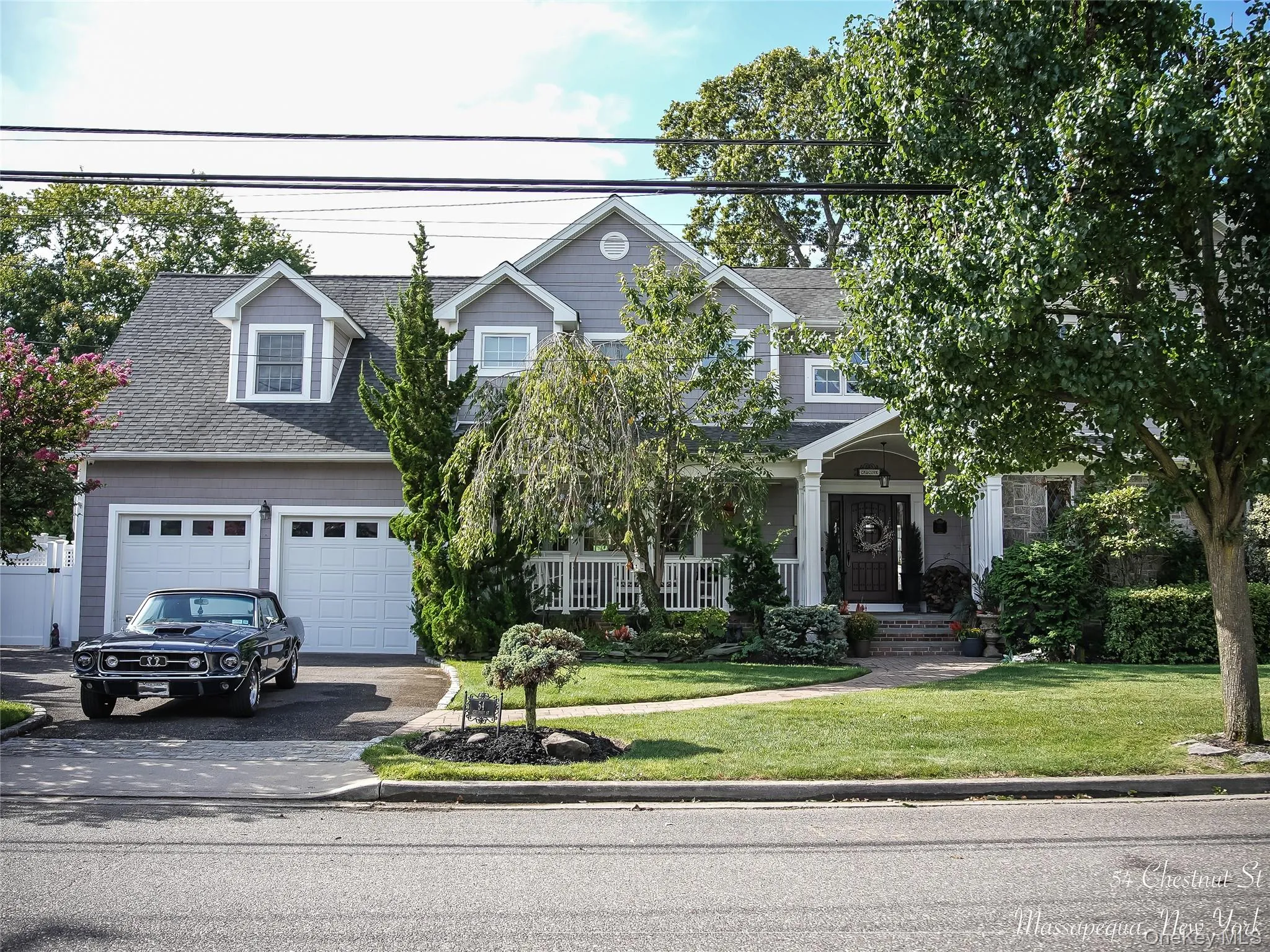 View of front of home with a front yard, a porch, driveway, a garage, and roof with shingles View of front of home with a front yard, a porch, driveway, a garage, and roof with shingles