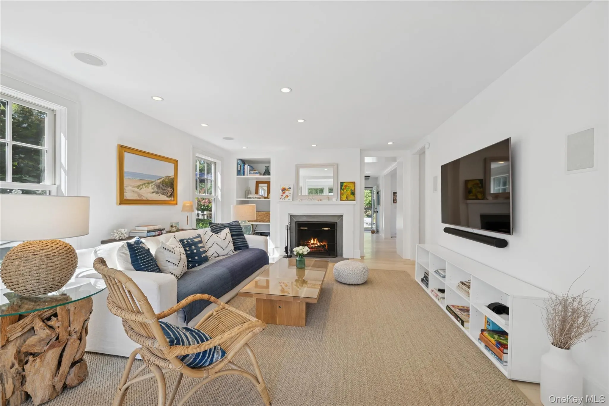 Living area with built in features, plenty of natural light, a warm lit fireplace, and recessed lighting Living area with built in features, plenty of natural light, a warm lit fireplace, and recessed lighting