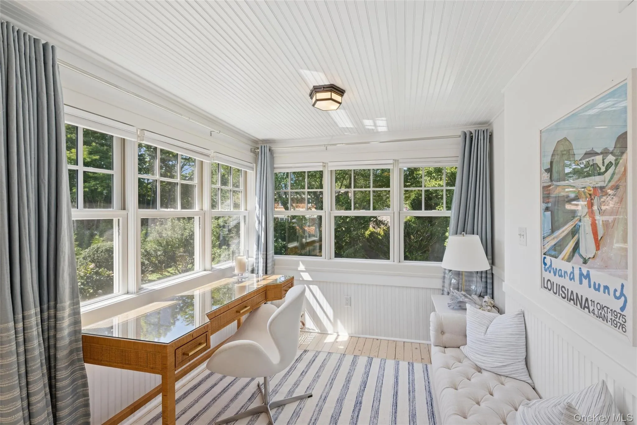 Sunroom / solarium featuring a wainscoted wall and wood finished floors Sunroom / solarium featuring a wainscoted wall and wood finished floors