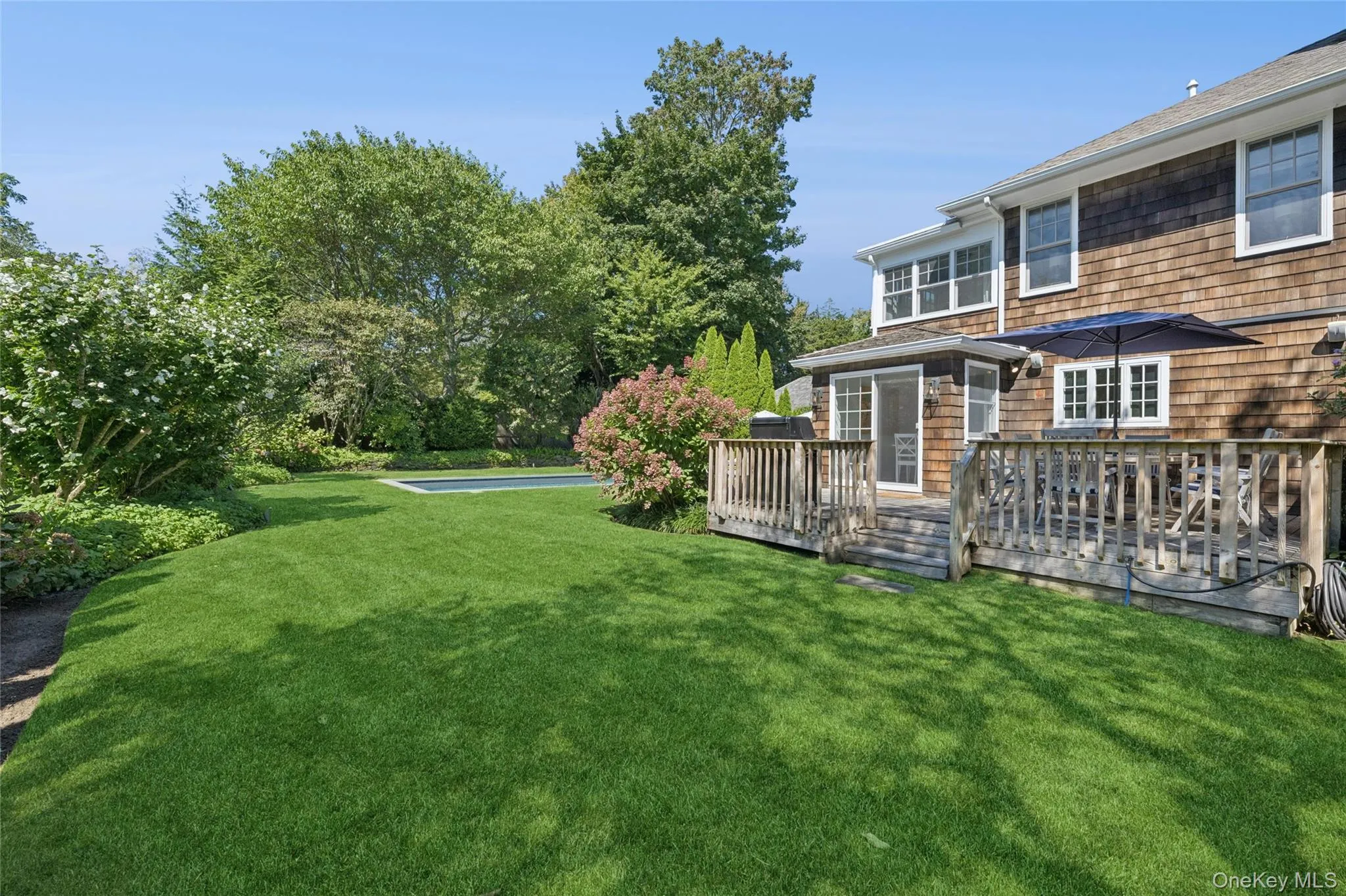 View of grassy yard featuring a deck View of grassy yard featuring a deck