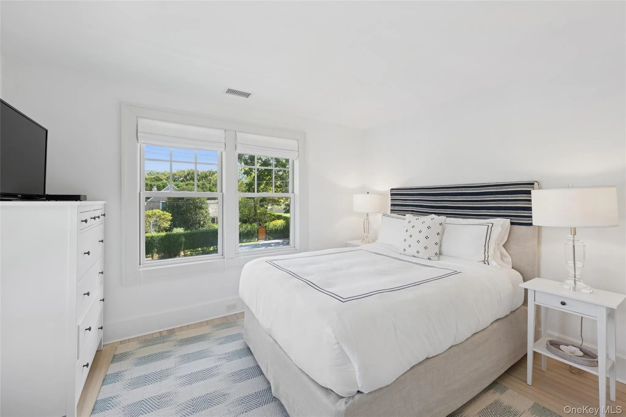 Bedroom featuring light wood finished floors and baseboards Bedroom featuring light wood finished floors and baseboards