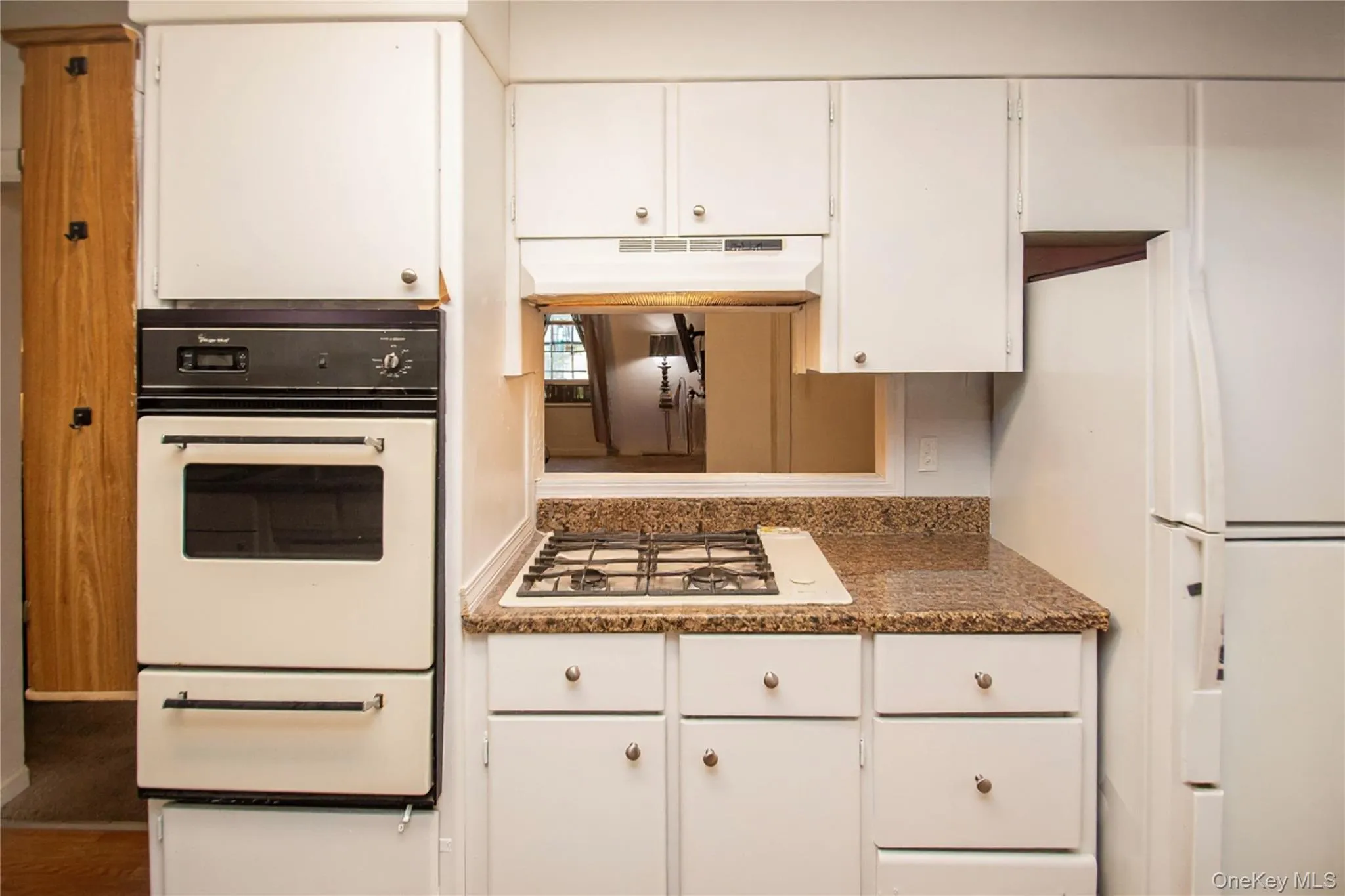 Kitchen featuring white cabinets, white appliances, and a warming drawer Kitchen featuring white cabinets, white appliances, and a warming drawer