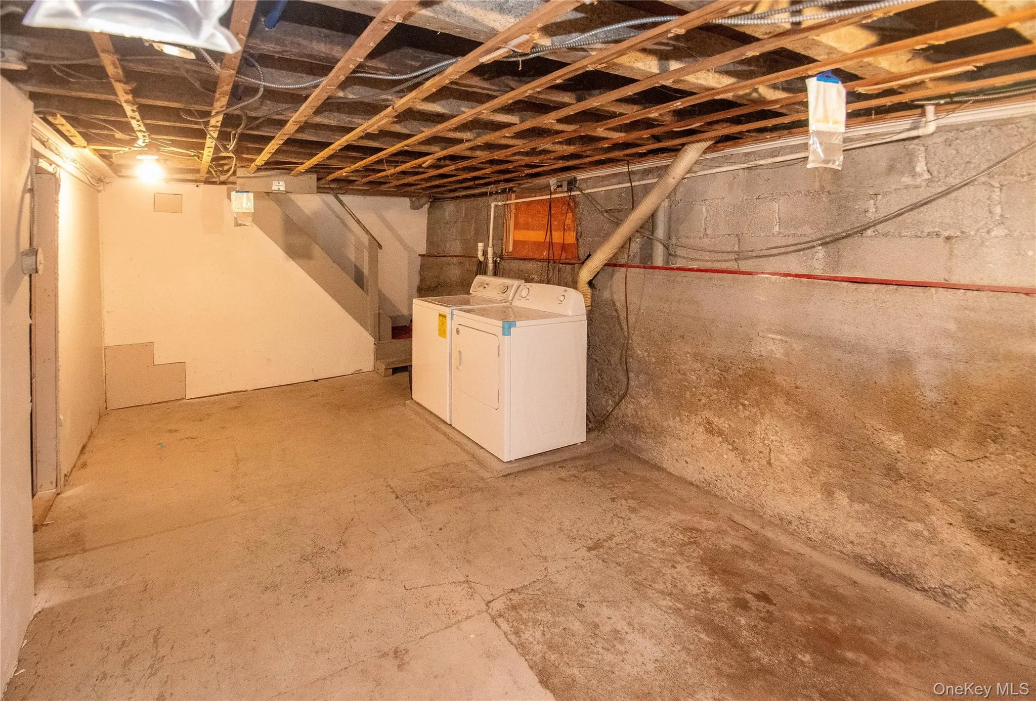 Unfinished below grade area featuring washing machine and clothes dryer Unfinished below grade area featuring washing machine and clothes dryer