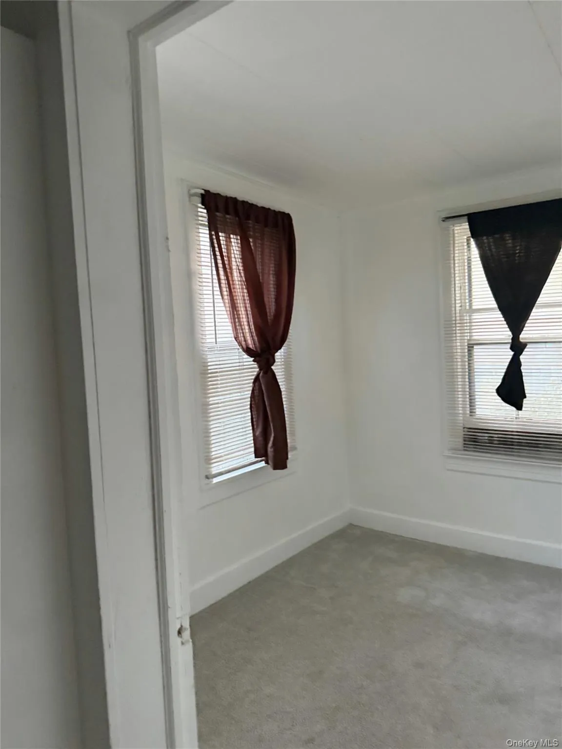 Unfurnished room featuring baseboards and light carpet Unfurnished room featuring baseboards and light carpet