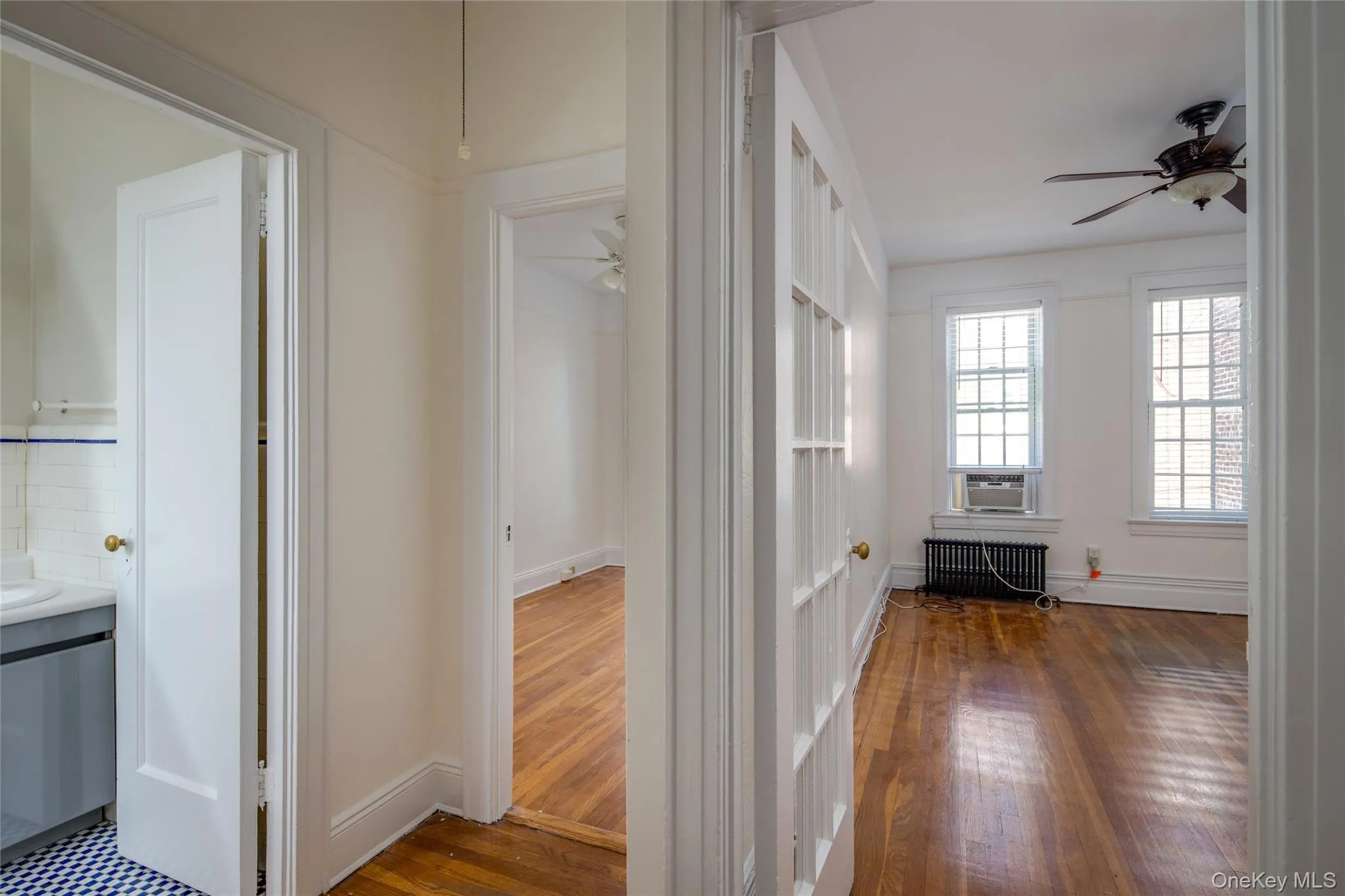 Corridor with dark wood-style flooring and radiator heating unit Corridor with dark wood-style flooring and radiator heating unit