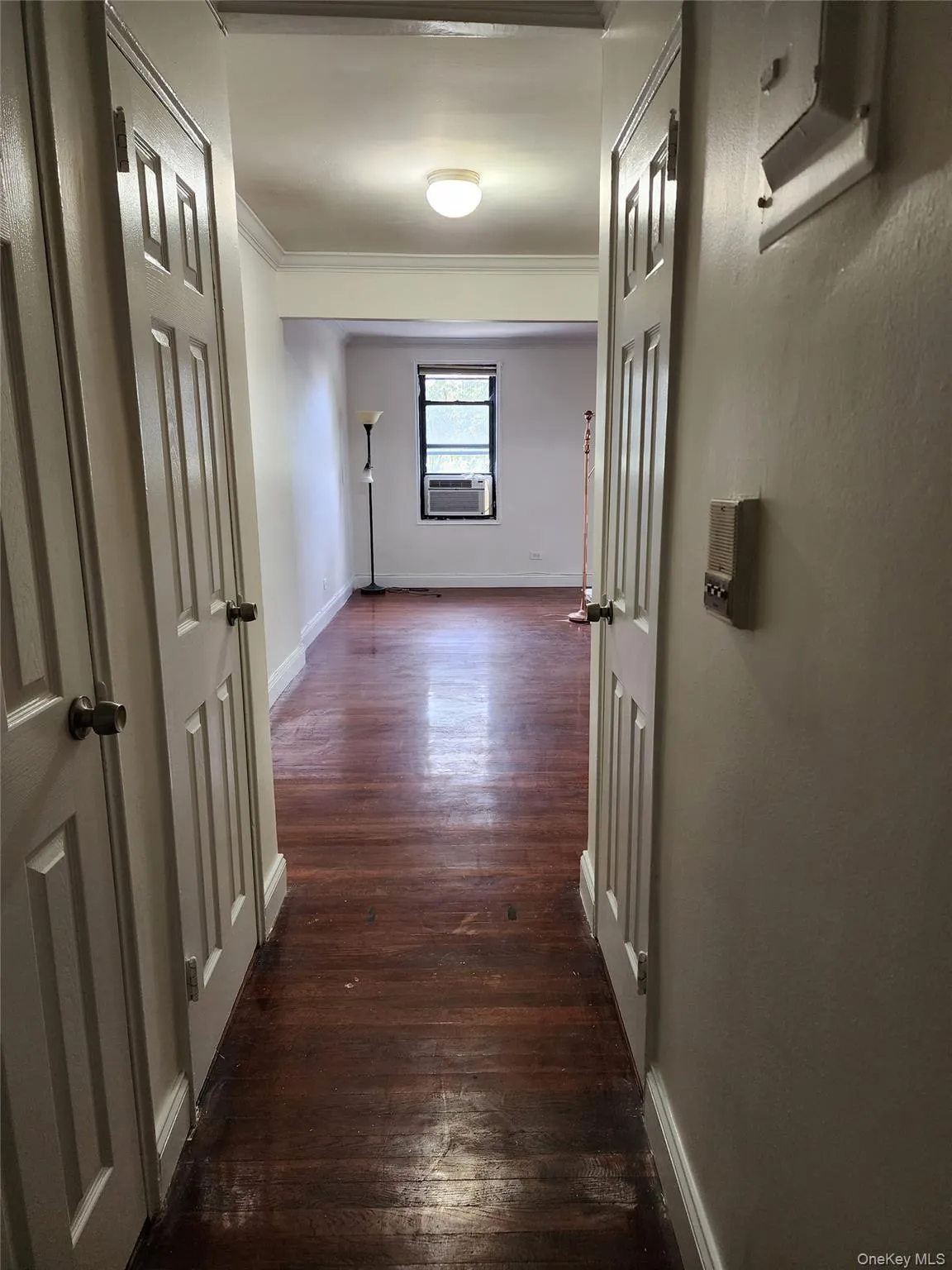 Corridor with dark wood-style floors and ornamental molding Corridor with dark wood-style floors and ornamental molding