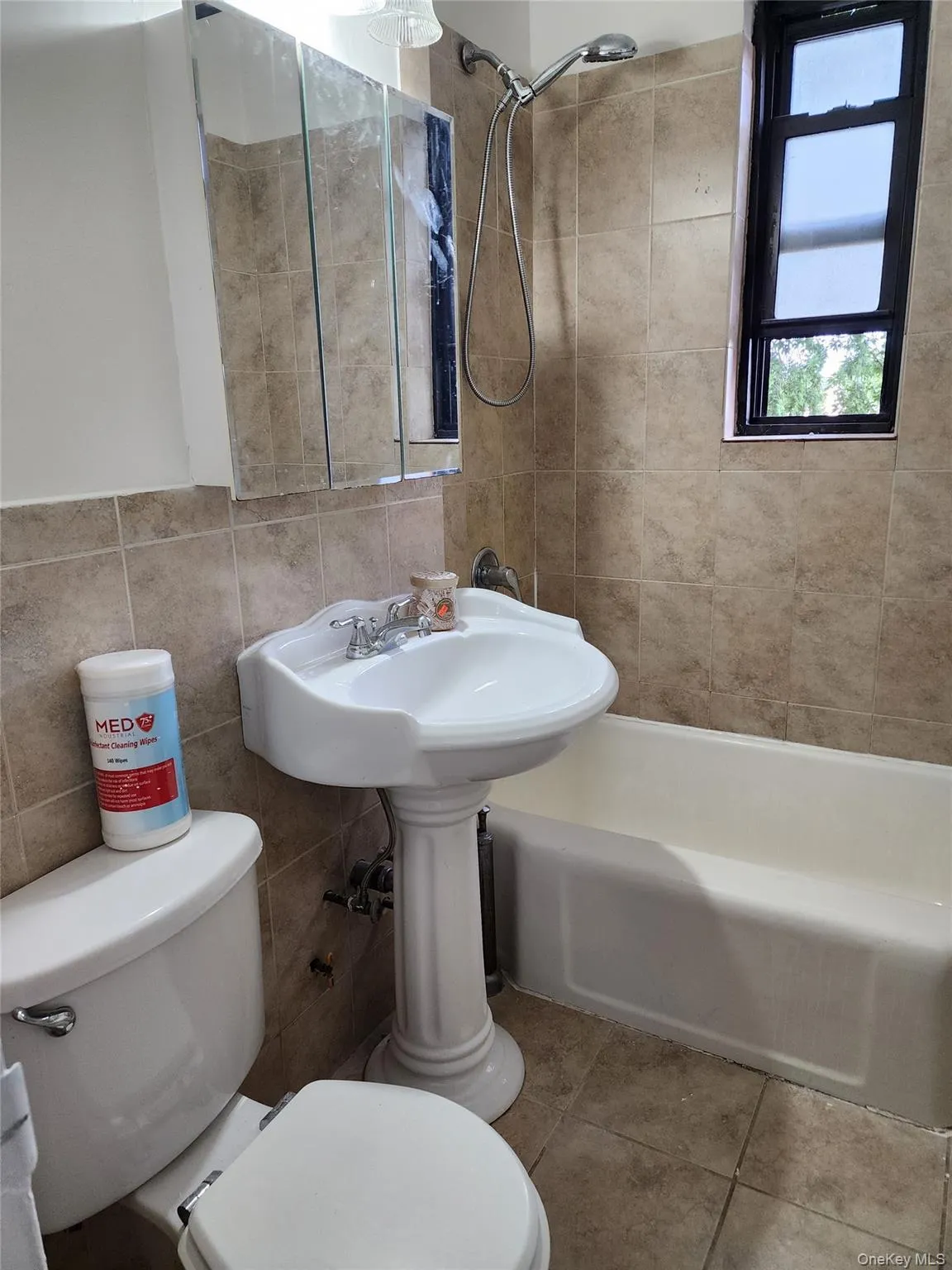 Bathroom featuring bathing tub / shower combination, tile walls, tile patterned flooring, and backsplash Bathroom featuring bathing tub / shower combination, tile walls, tile patterned flooring, and backsplash