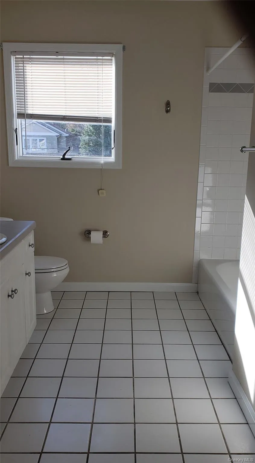 Bathroom with light tile patterned flooring, vanity, and bathtub / shower combination Bathroom with light tile patterned flooring, vanity, and bathtub / shower combination