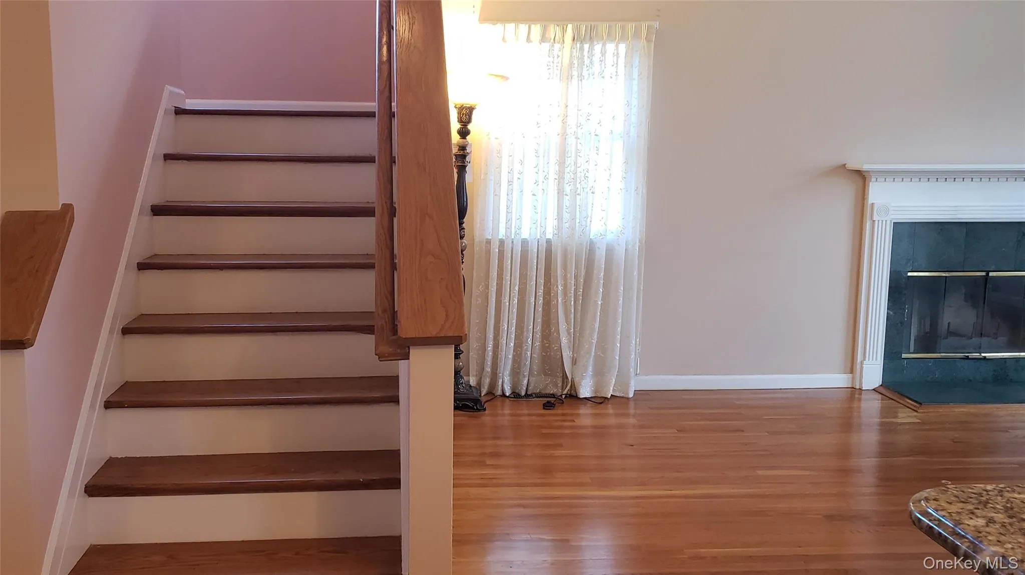 Stairs featuring wood finished floors and a glass covered fireplace Stairs featuring wood finished floors and a glass covered fireplace