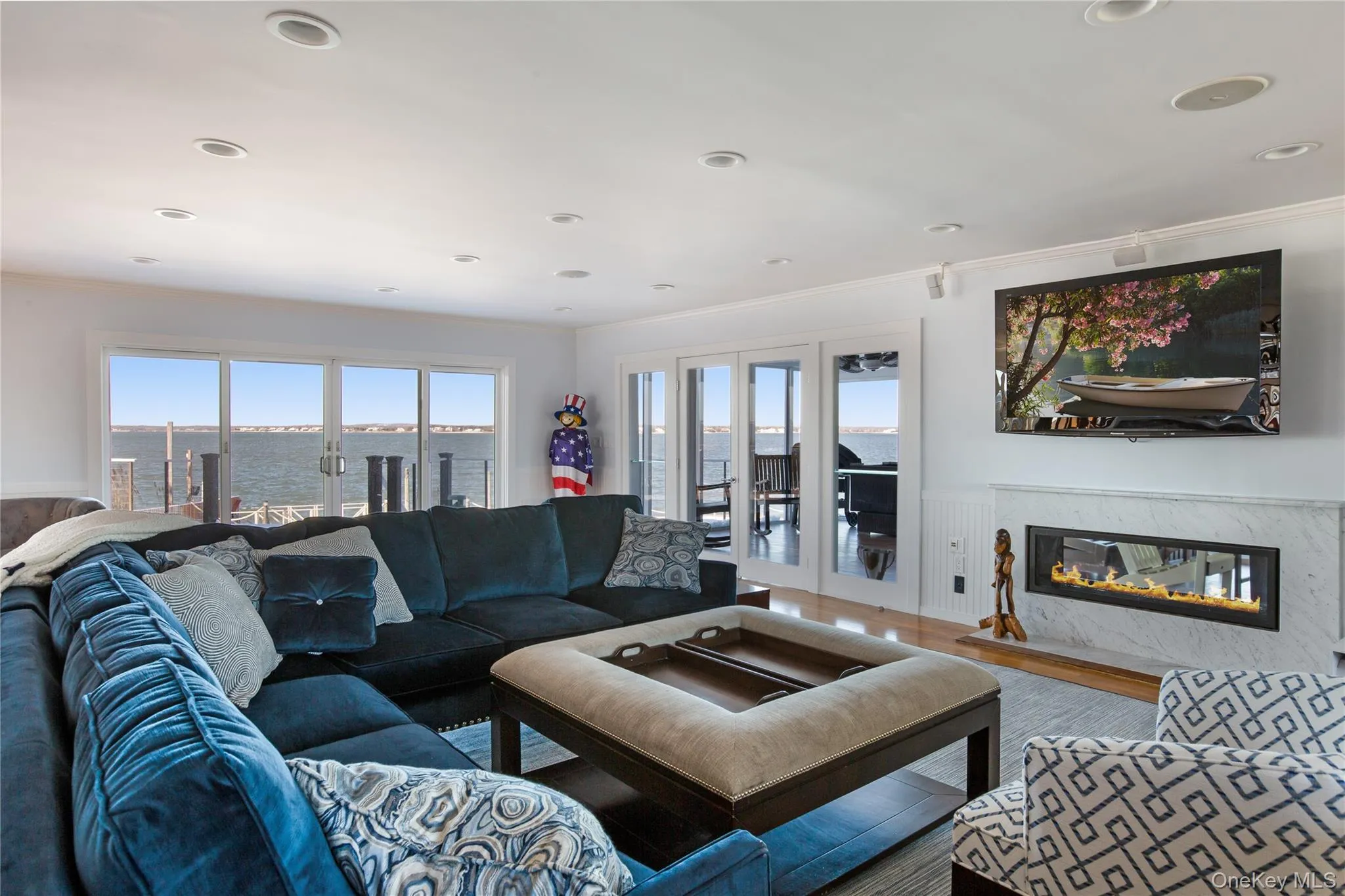 Living room featuring crown molding, a fireplace, healthy amount of natural light, french doors, and recessed lighting Living room featuring crown molding, a fireplace, healthy amount of natural light, french doors, and recessed lighting