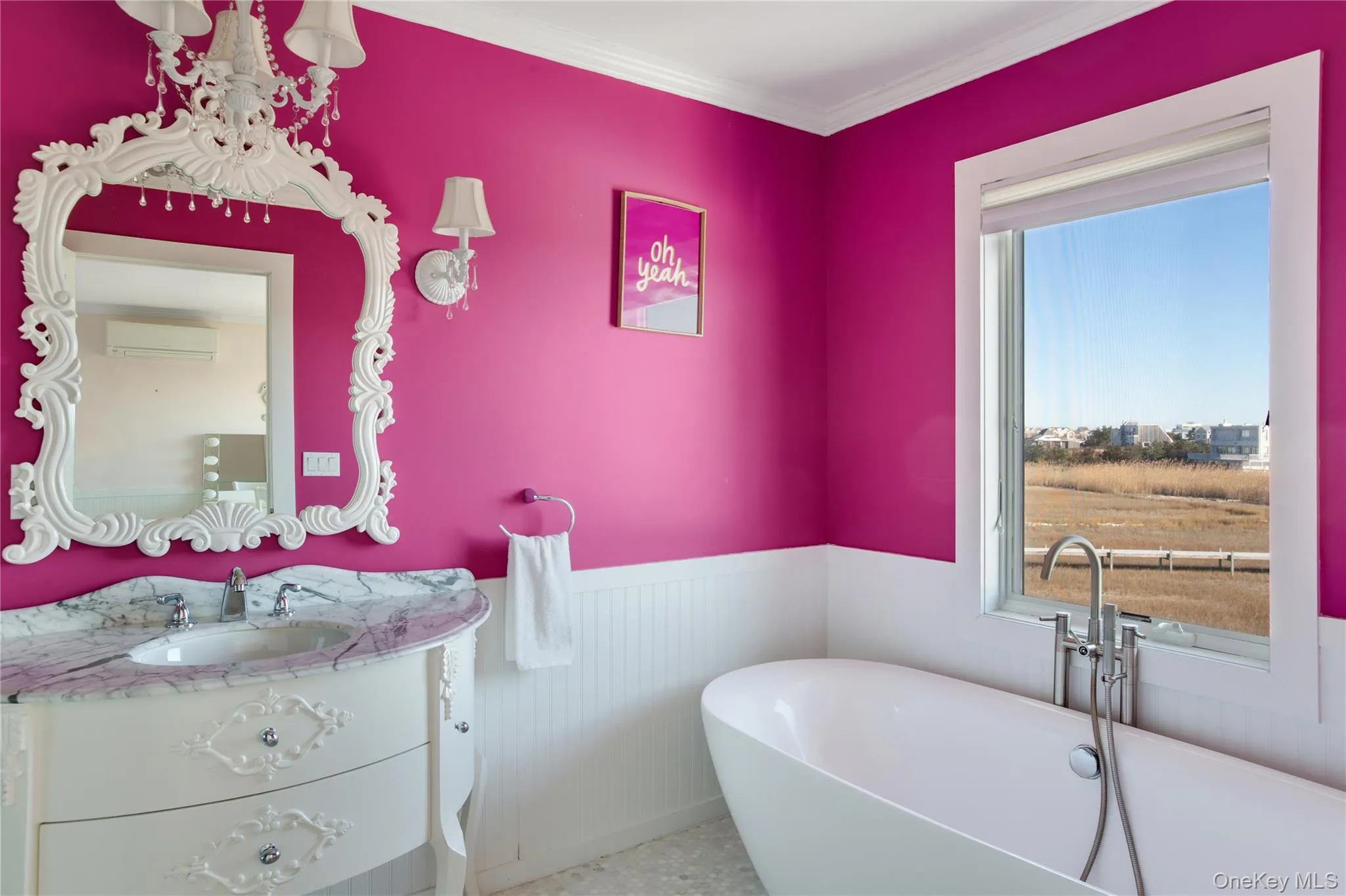 Bathroom with a freestanding tub, vanity, wainscoting, a wall mounted air conditioner, and crown molding Bathroom with a freestanding tub, vanity, wainscoting, a wall mounted air conditioner, and crown molding