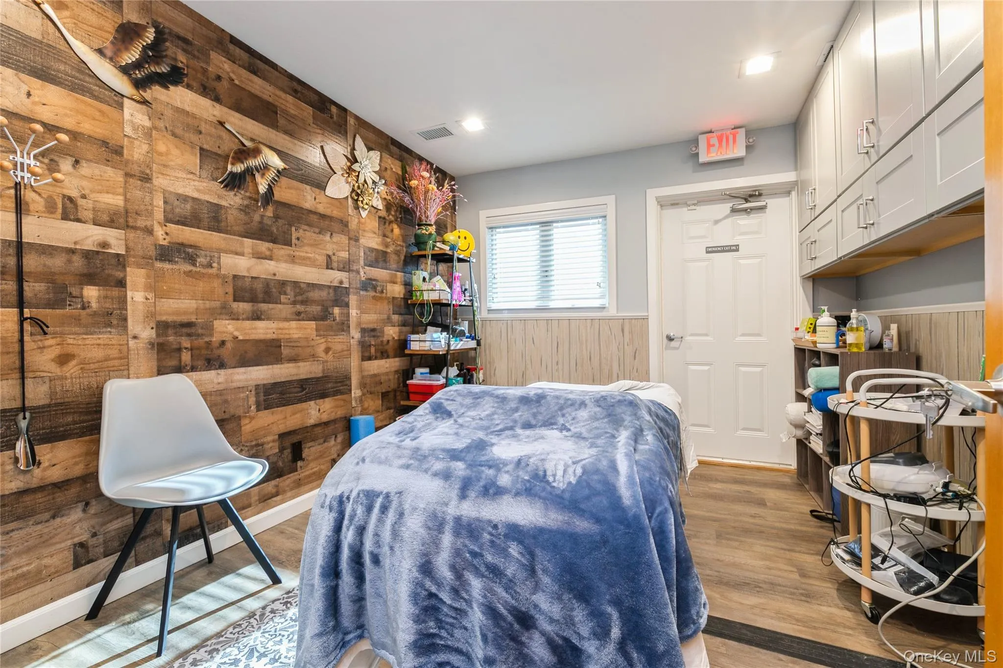 Treatment Room/ Office featuring dark wood finished floors, wood walls, and wainscoting, Storage Cabinet Treatment Room/ Office featuring dark wood finished floors, wood walls, and wainscoting, Storage Cabinet