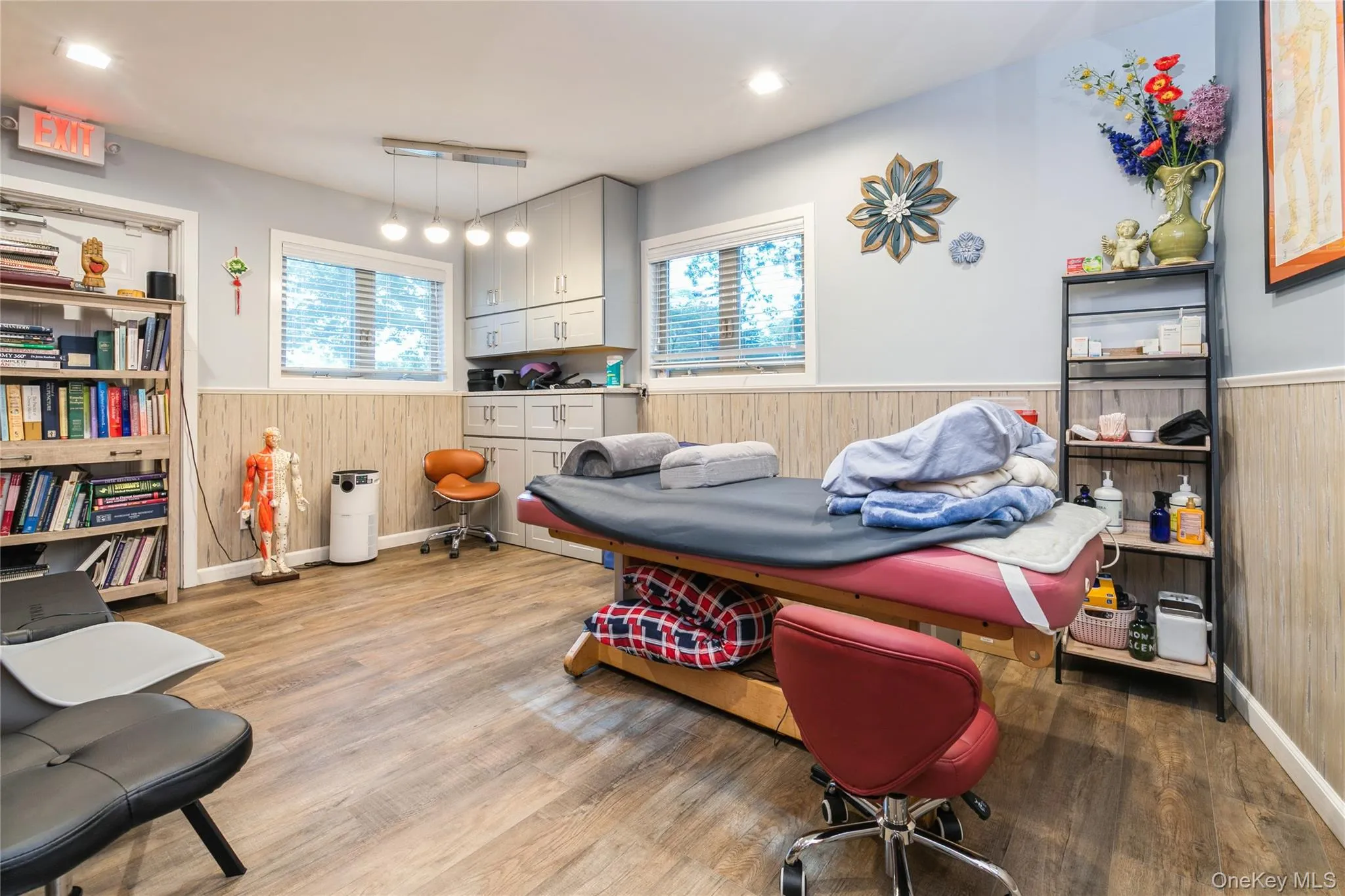 Treatment Room/ Office featuring dark wood finished floors, wood walls, and wainscoting, Storage Cabinet Treatment Room/ Office featuring dark wood finished floors, wood walls, and wainscoting, Storage Cabinet
