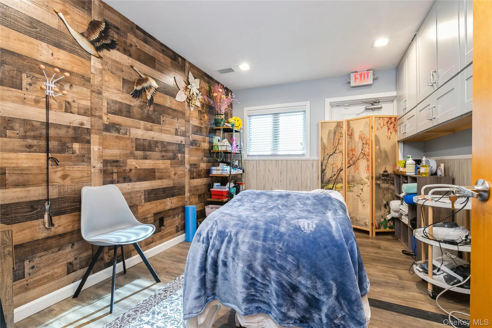Treatment Room/ Office featuring dark wood finished floors, wood walls, and wainscoting, Storage Cabinet Treatment Room/ Office featuring dark wood finished floors, wood walls, and wainscoting, Storage Cabinet