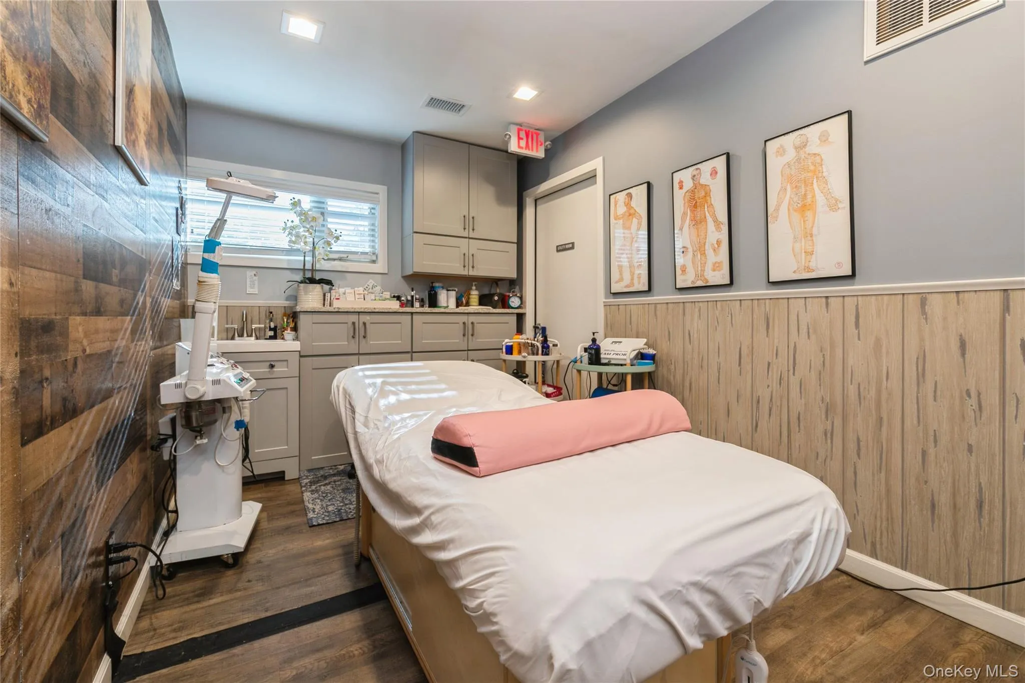 Treatment Room/ Office featuring dark wood finished floors, wood walls, and wainscoting, Storage Cabinet Treatment Room/ Office featuring dark wood finished floors, wood walls, and wainscoting, Storage Cabinet