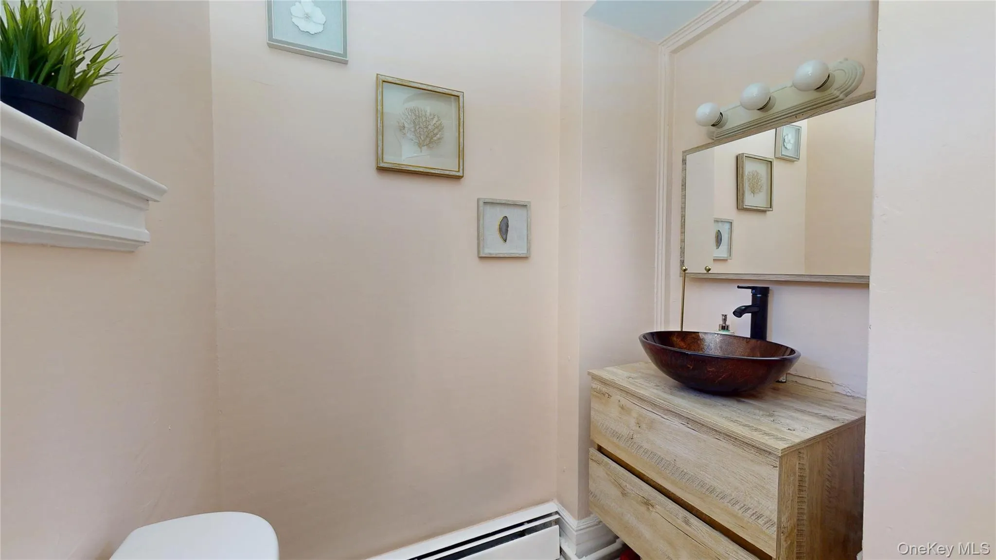 Half bathroom with vanity and baseboard heating Half bathroom with vanity and baseboard heating