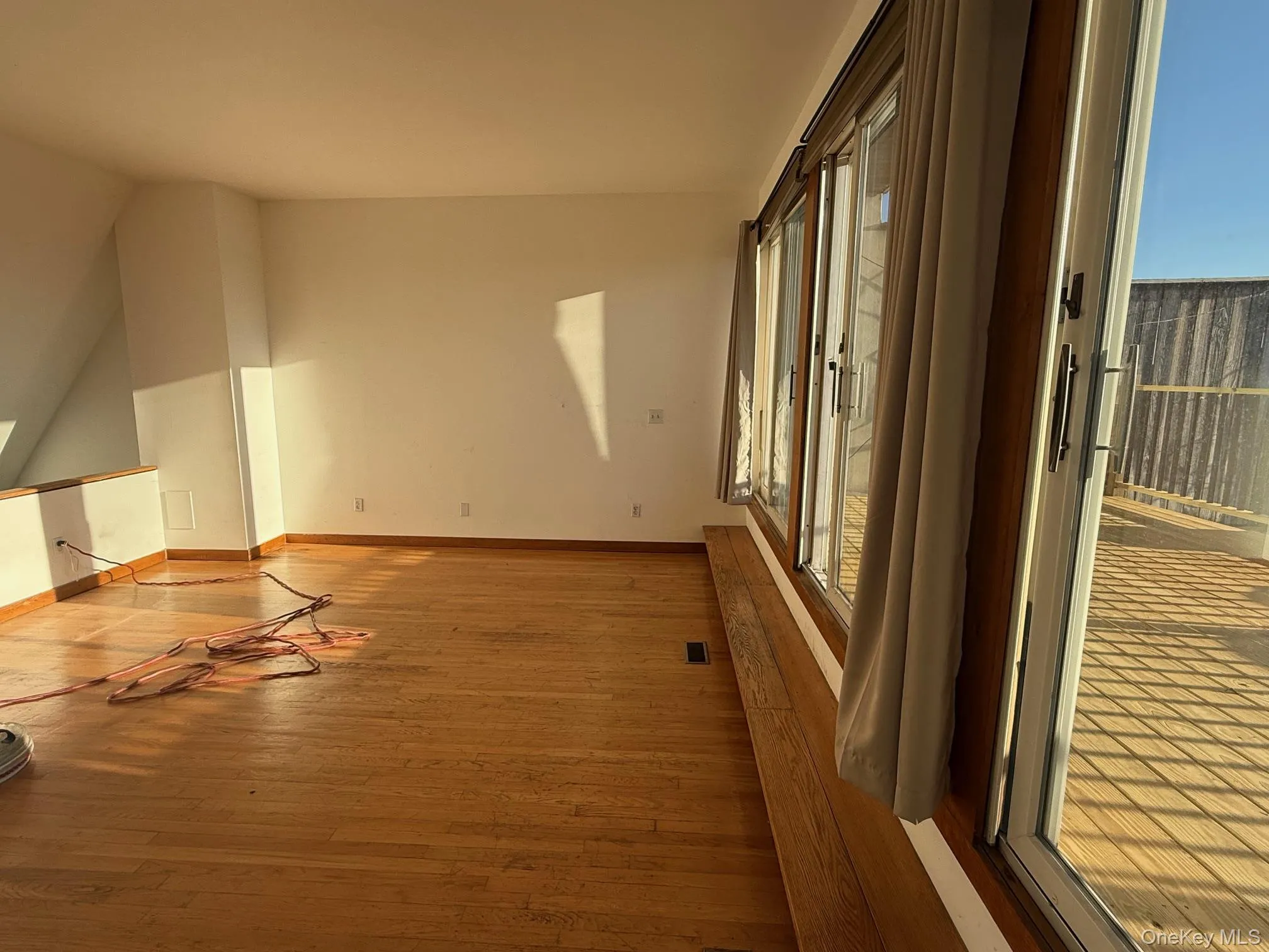 Spare room featuring wood finished floors and vaulted ceiling Spare room featuring wood finished floors and vaulted ceiling