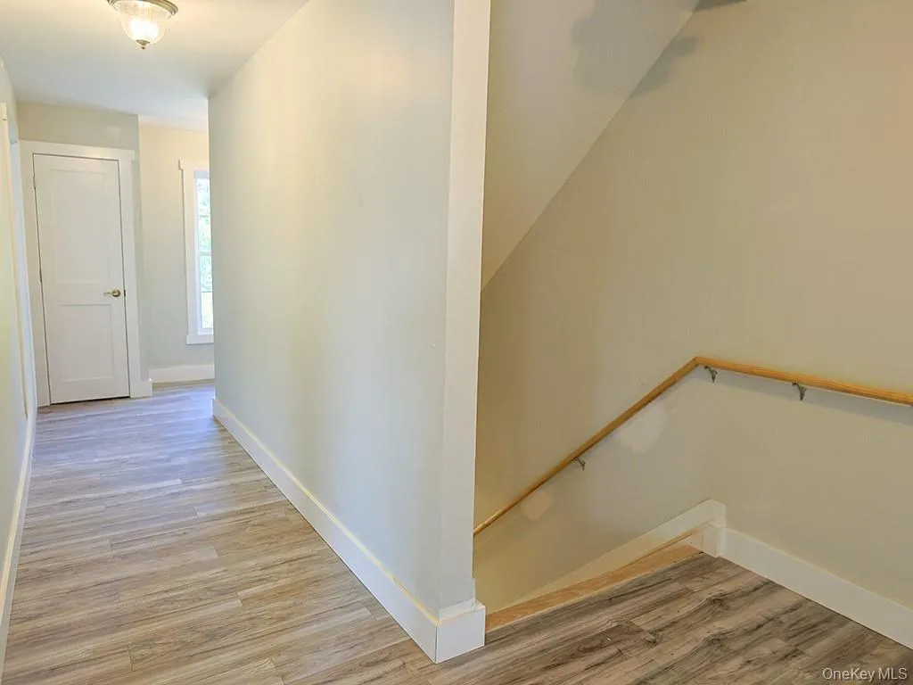 Hall with light wood finished floors and an upstairs landing Hall with light wood finished floors and an upstairs landing