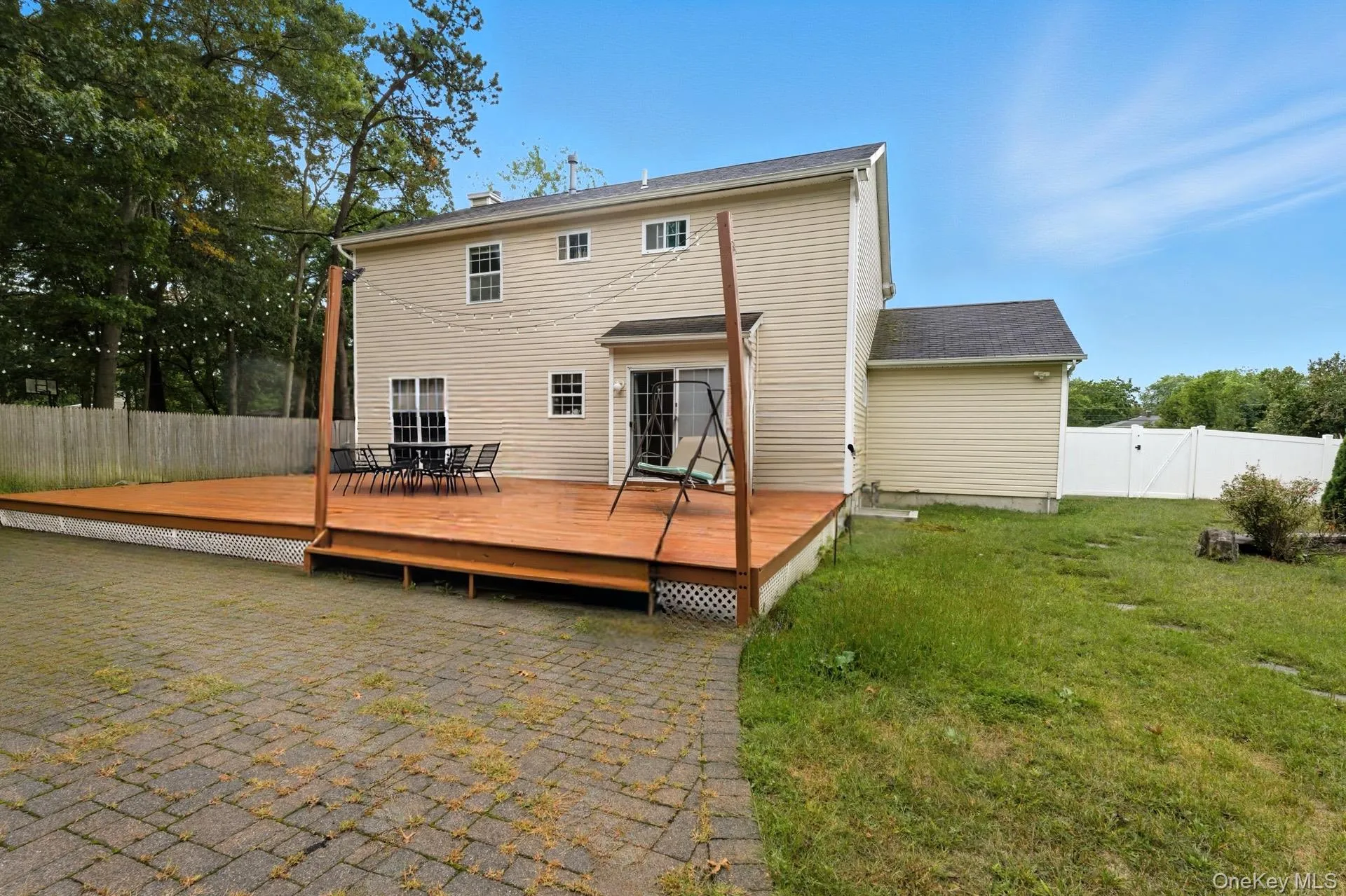 Back of house featuring a fenced backyard, a gate, and a deck Back of house featuring a fenced backyard, a gate, and a deck