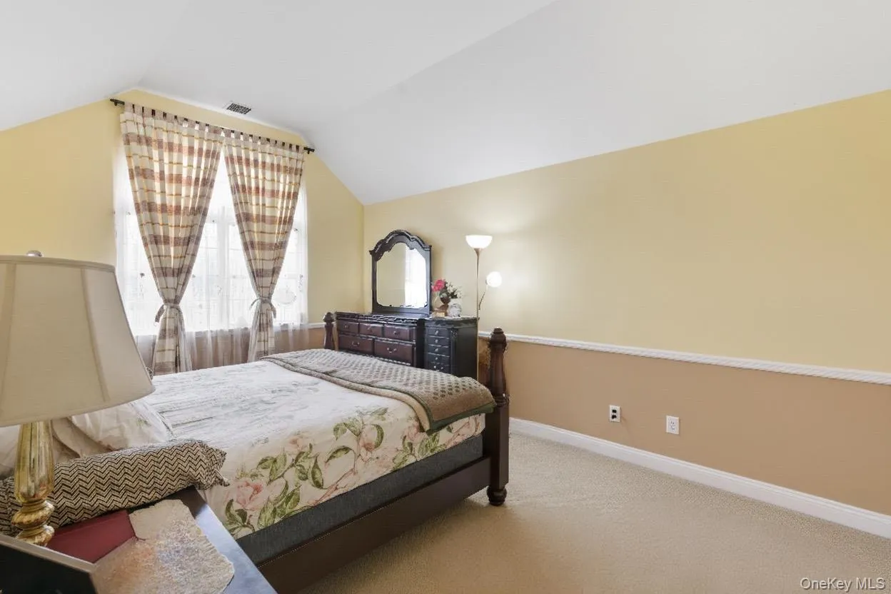 Bedroom with carpet and lofted ceiling Bedroom with carpet and lofted ceiling