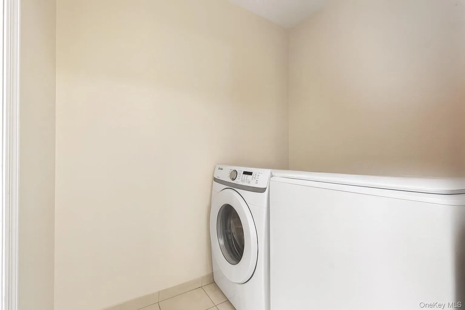 Washroom with light tile patterned floors and baseboards Washroom with light tile patterned floors and baseboards