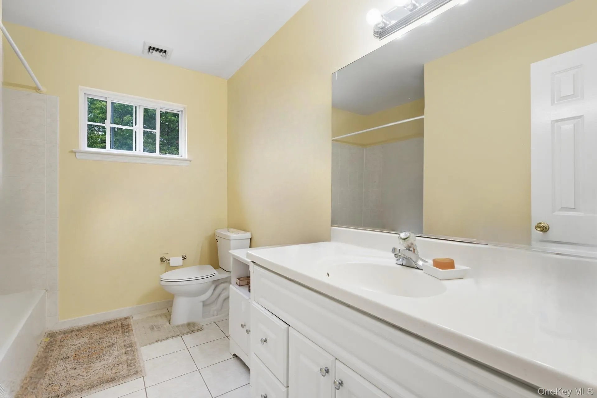 Full Bathroom featuring vanity, light tile patterned floors, and shower / tub combination Full Bathroom featuring vanity, light tile patterned floors, and shower / tub combination